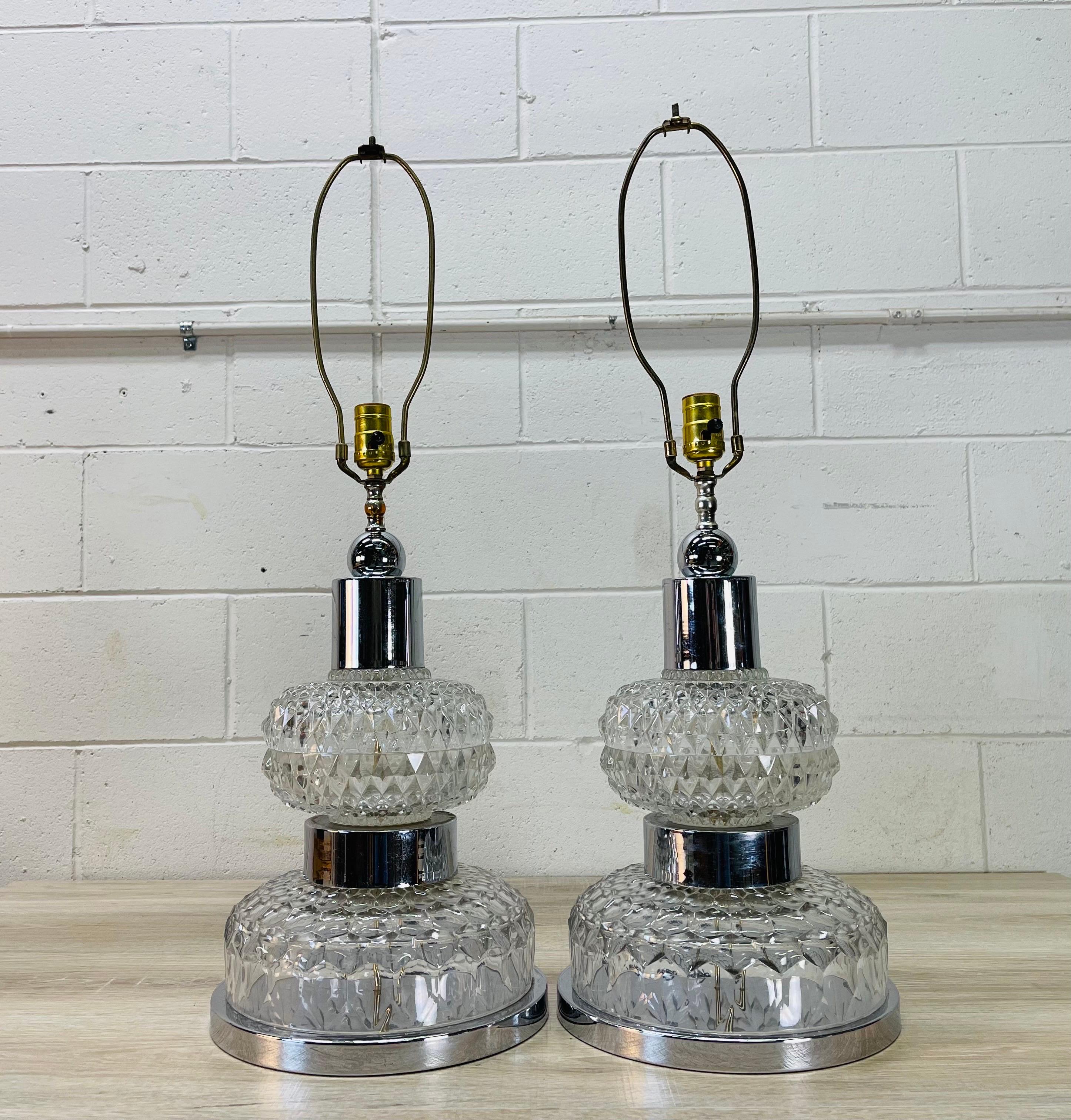 Vintage 1970s pair of chrome and glass table lamps. The glass has a diamond pattern design. The lamps are large and heavy. Wired for the US and in working condition. Socket, 19.75”height. Harp, 4.5”diameter x 10”height. The glass and chrome are both