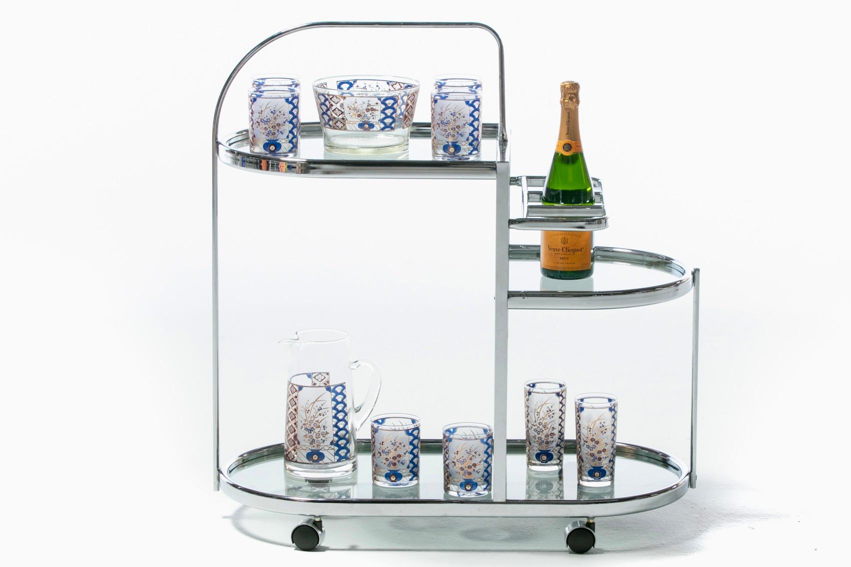 With an almost Art Deco inspired skyscraper silhouette, this sleek and sexy 1970s chrome bar cart rises up in layers of chrome, glass and softly rounded edges. The look is modern, clean and light. The bar cart features three glass top shelves. Top