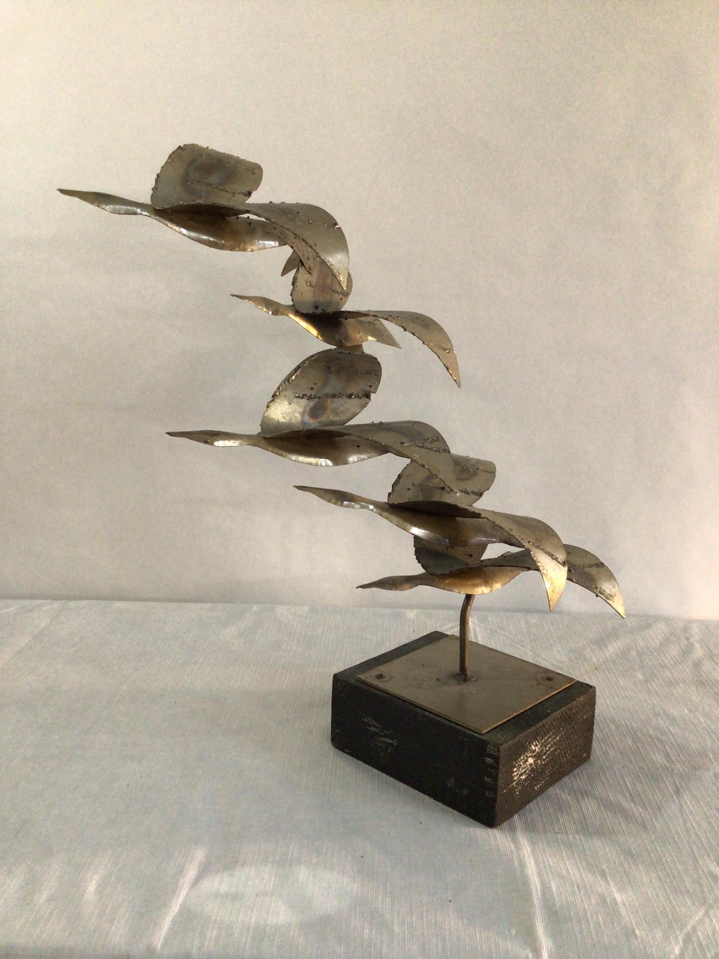 1970s Chrome Sculpture of Birds in Flight on Painted Wood Base
5 Birds Ascending in Flight
Vintage Brutalist sculpture
Richly textured with patinated torch cut metal mounted atop a charcoal colored wood base
Sculpture is finished in the round.