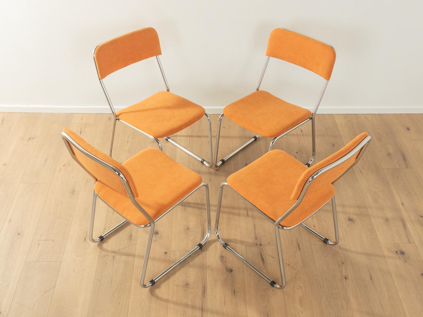 Chaises classiques des années 1970 avec une structure en tube d'acier inoxydable chromé. Les coques d'assise et les dossiers ont été retapissés avec un tissu d'ameublement de haute qualité de couleur orange. L'offre comprend quatre
