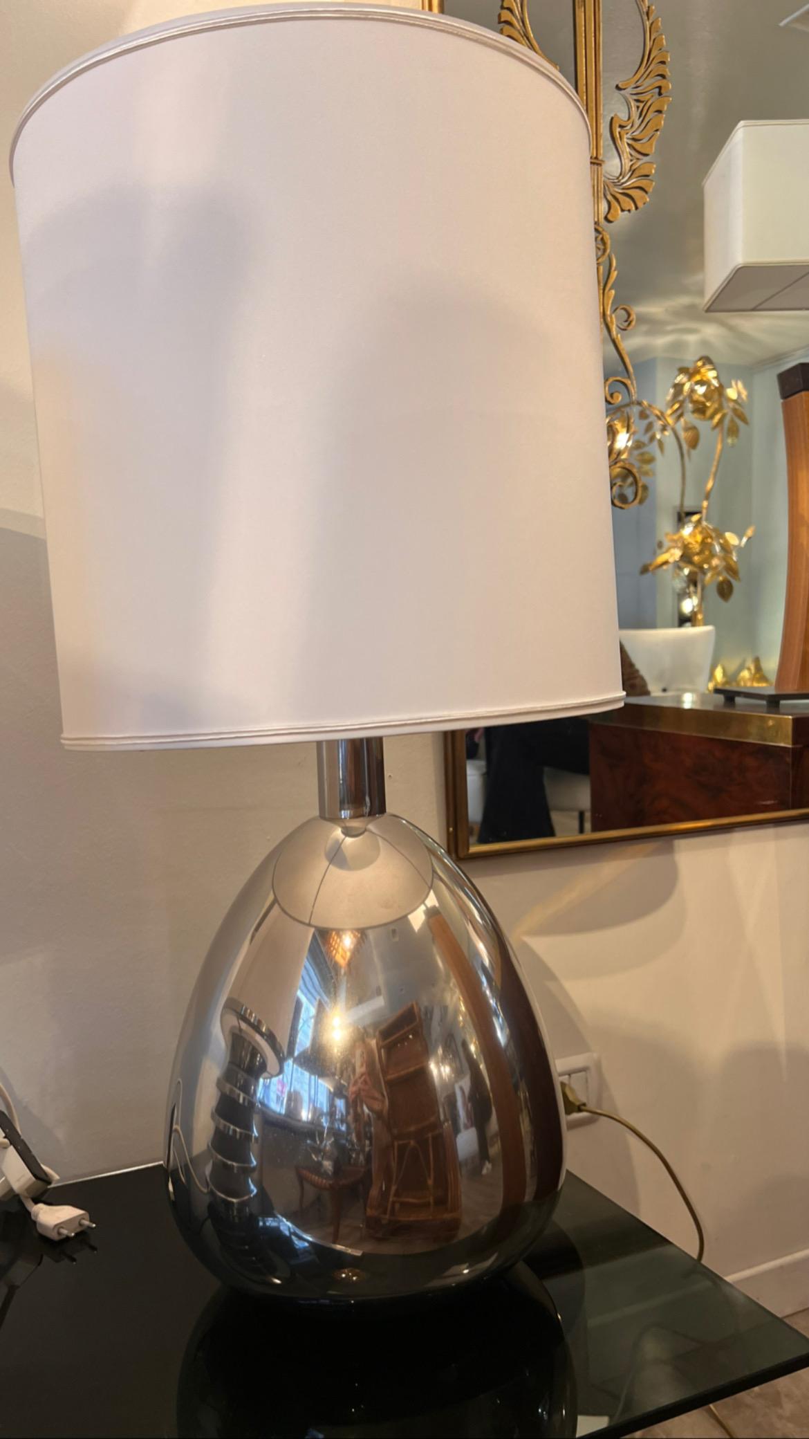 Lampe de table en acier chromé des années 1970 avec abat-jour blanc. 
Cette lampe est de forme ovoïde et possède un système de câblage original.
Taille de la lampe : 