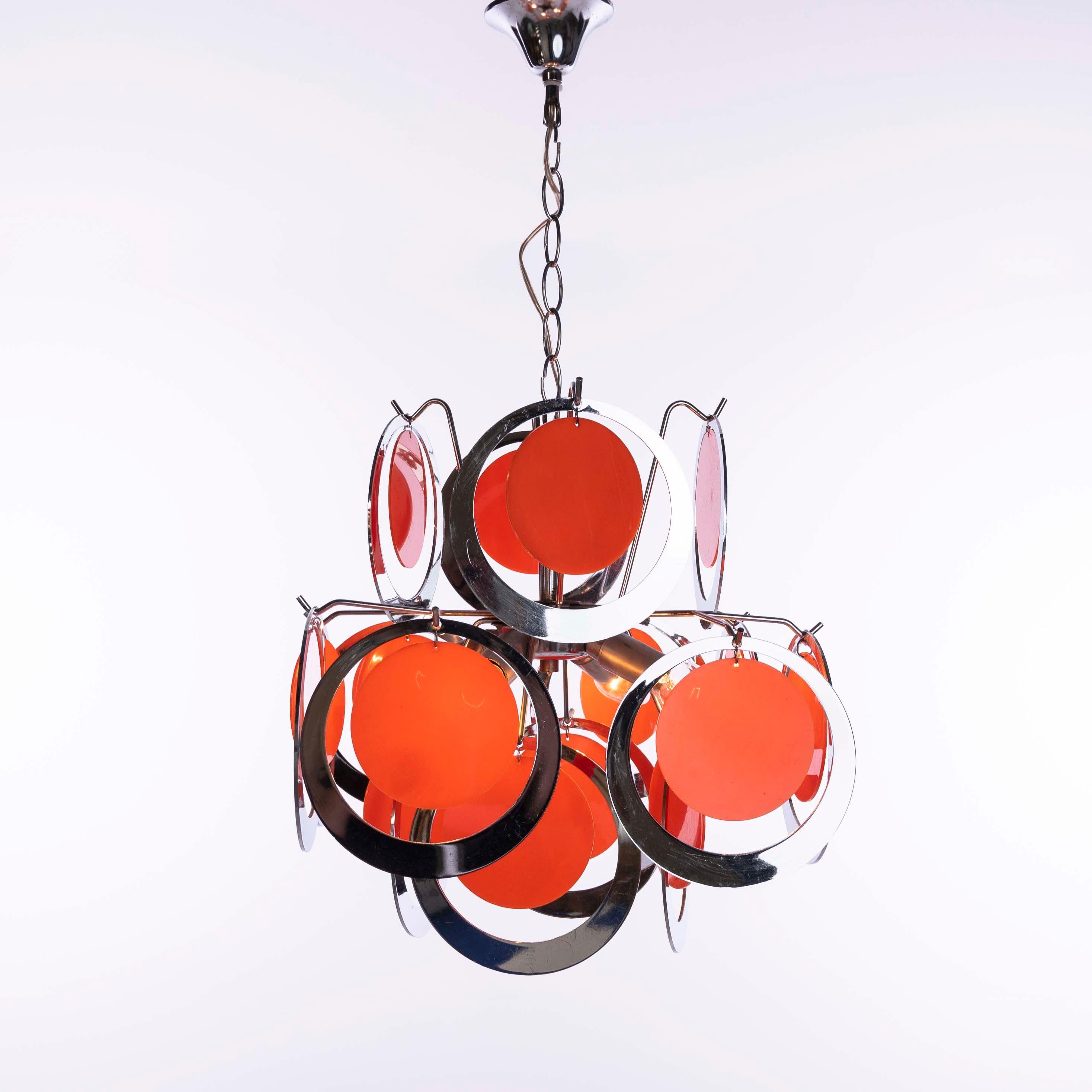 Fröhlicher Kronleuchter mit verchromten Kunststoffringen und orangefarbenen Kunststoffkreisen. Leuchte ohne Kette Höhe 46cm, 4 Glühbirnen, 16 runde Ringe plus 16 orangefarbene Kreise.