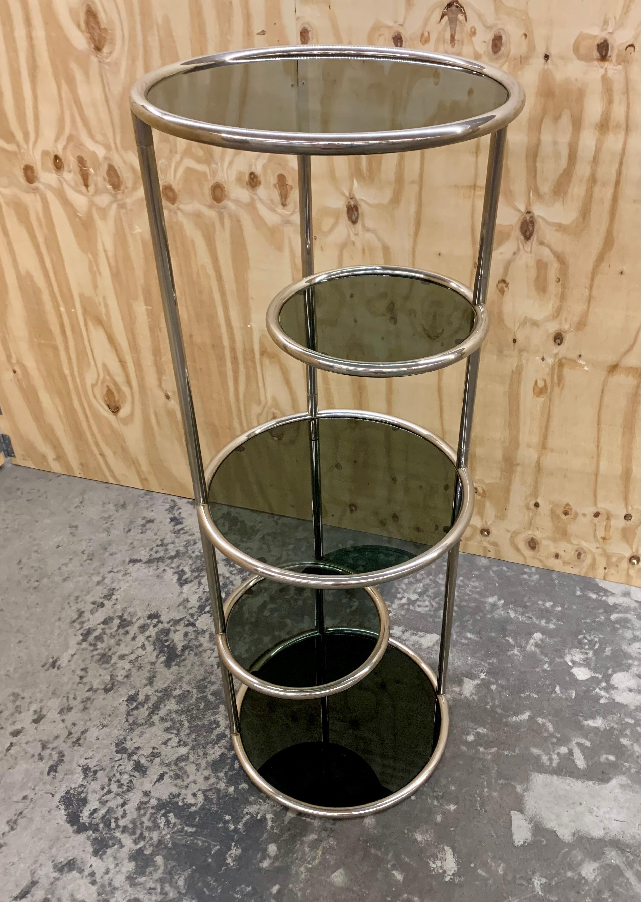 Divertente e decorativa scaffalatura Space AGE in cromo e vetro fumé con 3 ripiani circolari grandi e 2 piccoli. Un ottimo espositore per la casa e per il negozio. I due piccoli ripiani possono essere spostati in dentro o in fuori a seconda delle