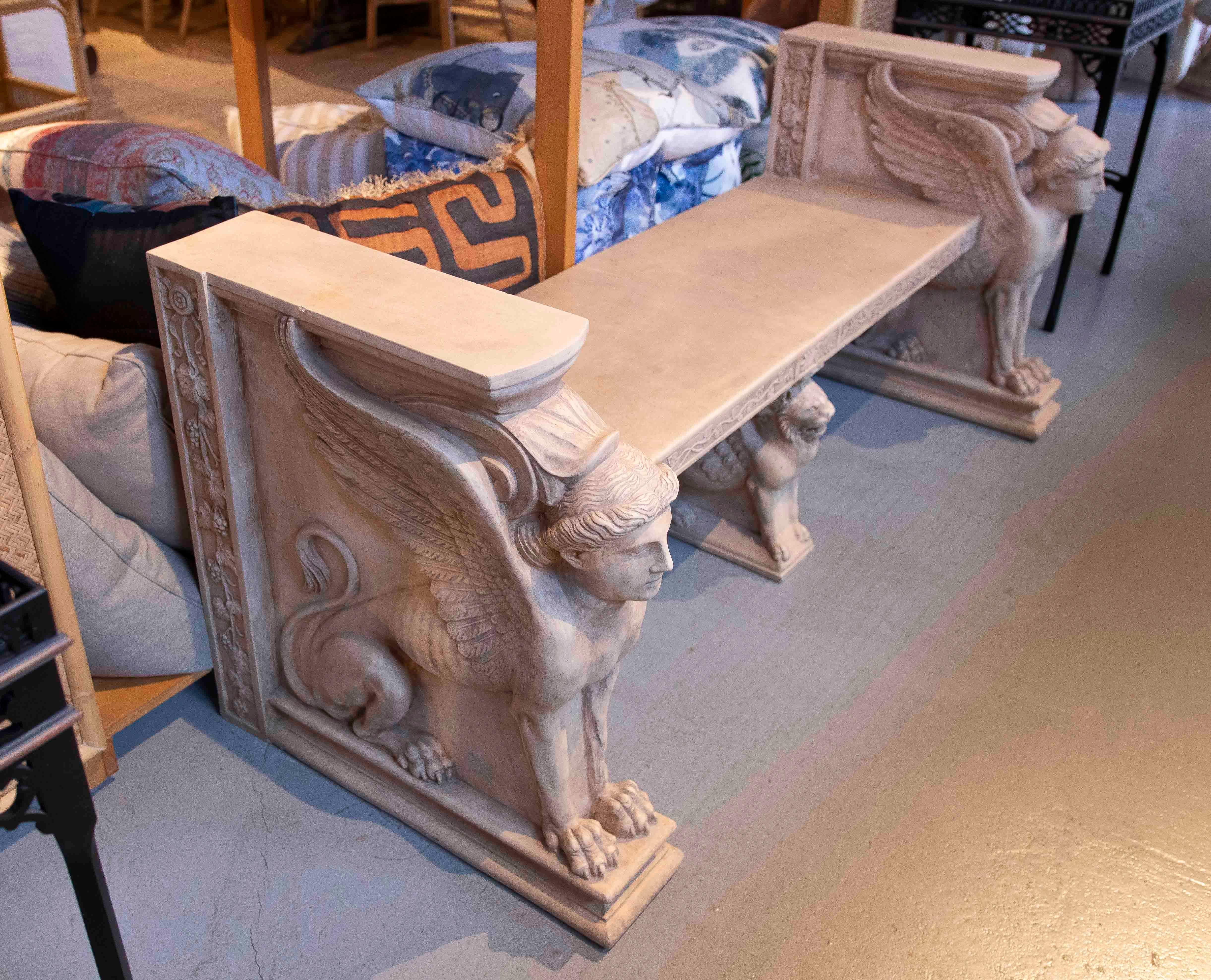 Majestic terracotta bench inspired by classical art, with sides ornamented with imposing hand-carved winged sphinxes. This piece evokes the grandeur of ancient architecture and is ideal for gardens, patios or interiors with a sophisticated and