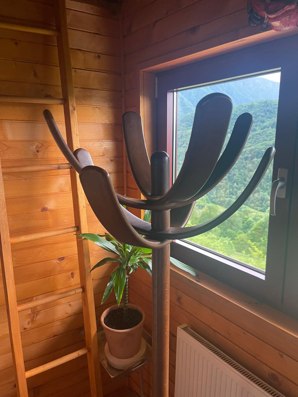 This lacquered beech 'Cactus' coat rack, designed by Mario Pasquinelli and produced by Pallavisini Italia (Udine) between 1970 and 1979, is a unique freestanding piece with a cylindrical central shaft supported by a cruciform base. The distinctive