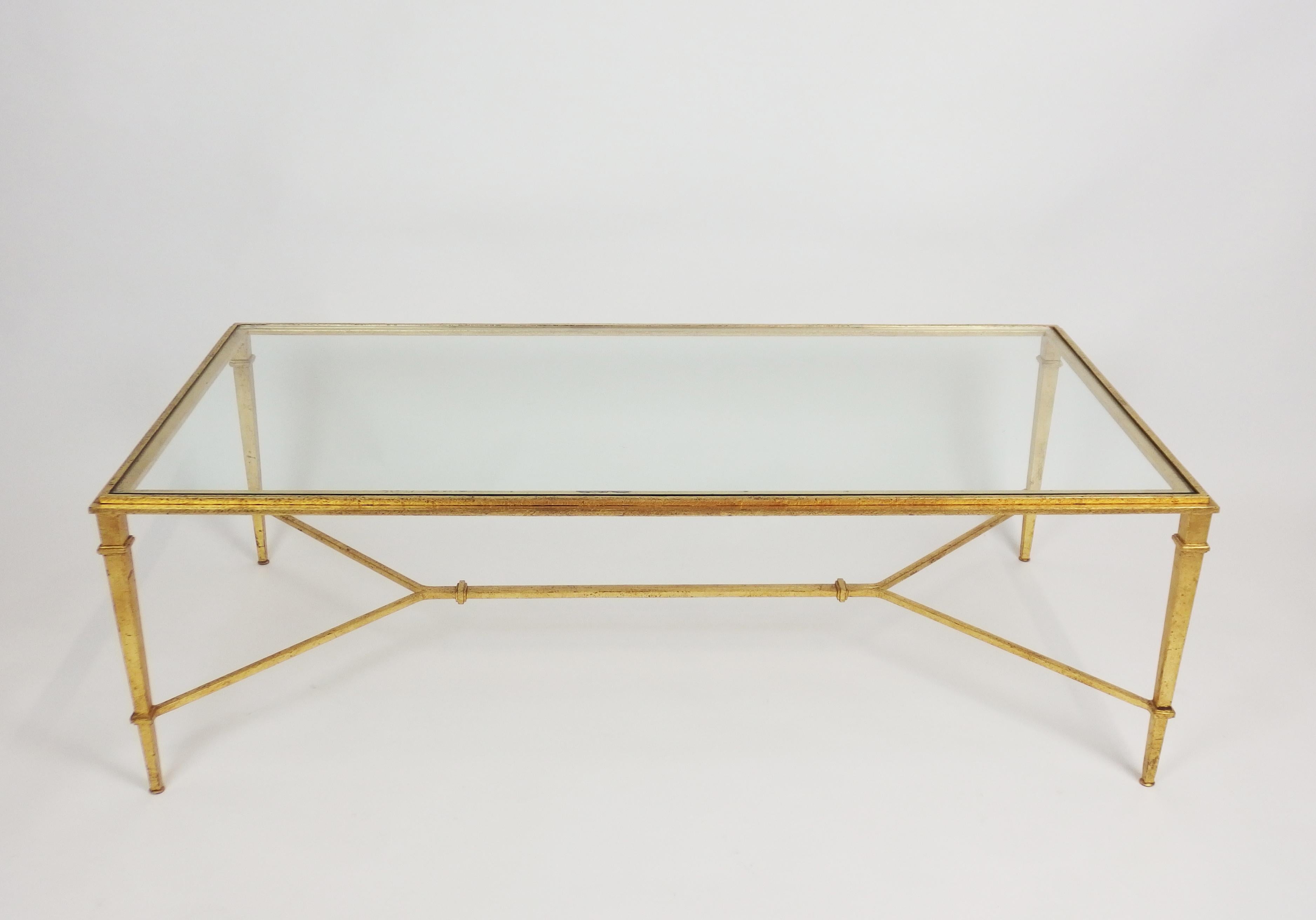 Refined styling gilt wrought iron coffee table with adjustable table base screws and translucent glass top. Designed by Robert & Roger Thibier & stamped R Thibier.