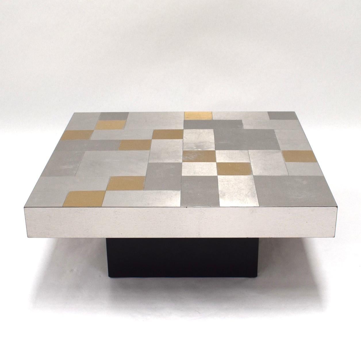 Seventies coffee table with aluminium mosaic top in silver and gold color.

Designer: Unknown

Manufacturer: Unknown

Country: Unknown

Model: Coffee table

Material: Aluminium / Black lacquered wood

Design period: 1970s

Date of