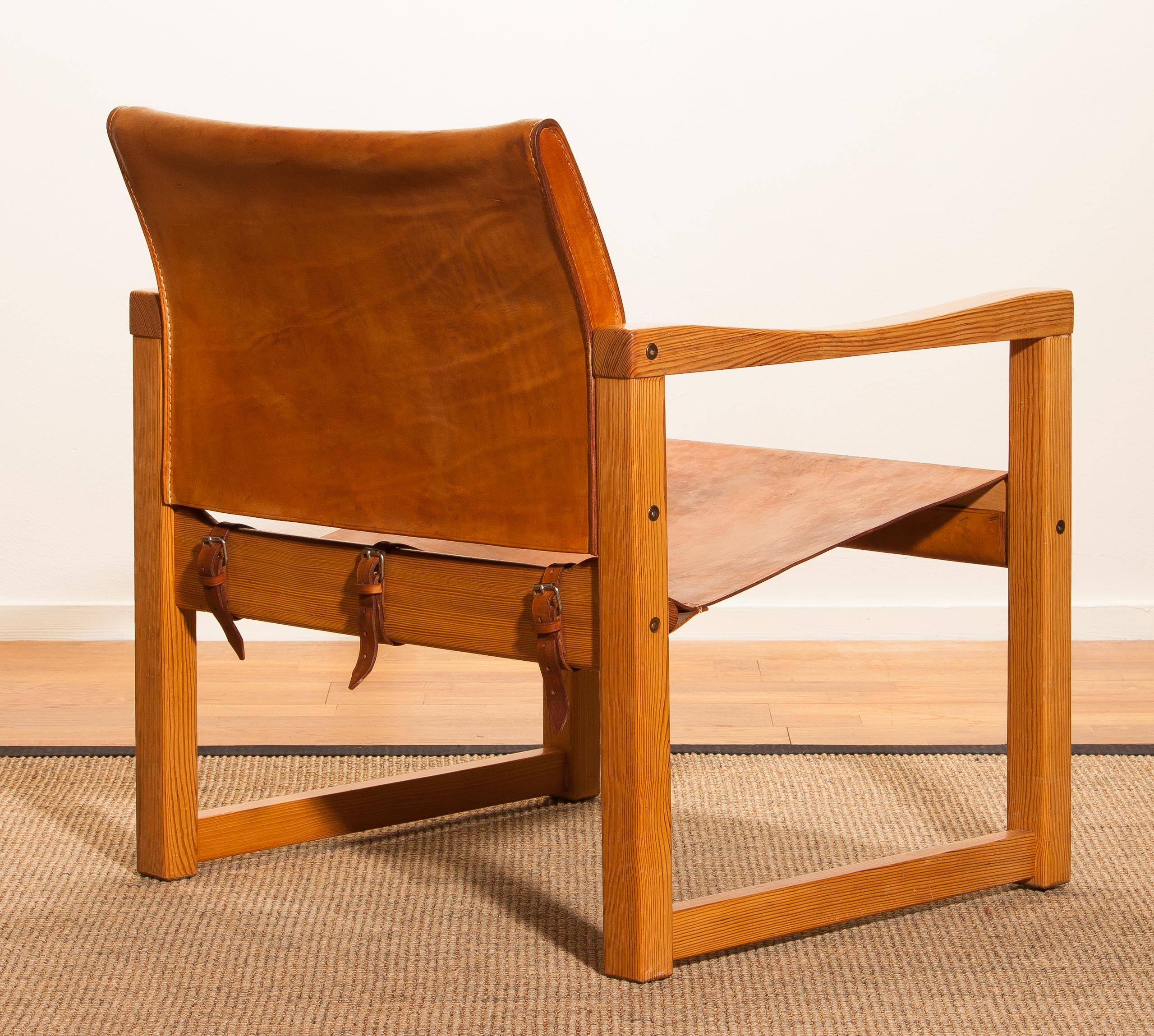This elegant leather “Safari” chair designed by the Swedish designer Karin Mobring and produced in the 1970s. 
The chair's frame is made of pine. 
The seating/backrest and belts are made of very thick and sturdy cognac leather and in very good