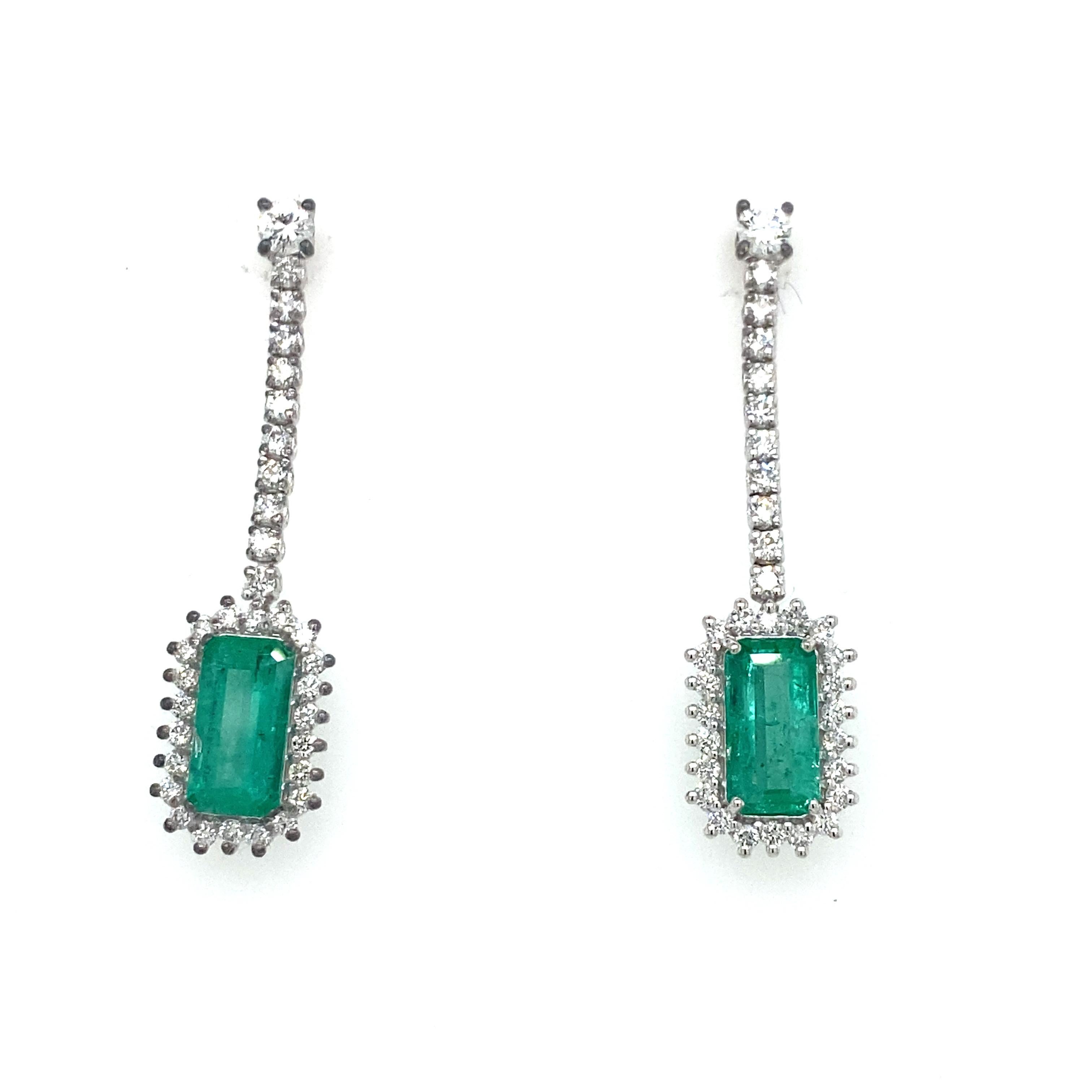 Elegant pair of earrings handmade in 18 kt gold. The two splendid natural emeralds with a vivid green color (emerald cut - total 1.60 ct) surrounded by 48 round brilliant-cut natural diamonds (VVS - G Color - 1.20 ct) stand out, the two diamonds at