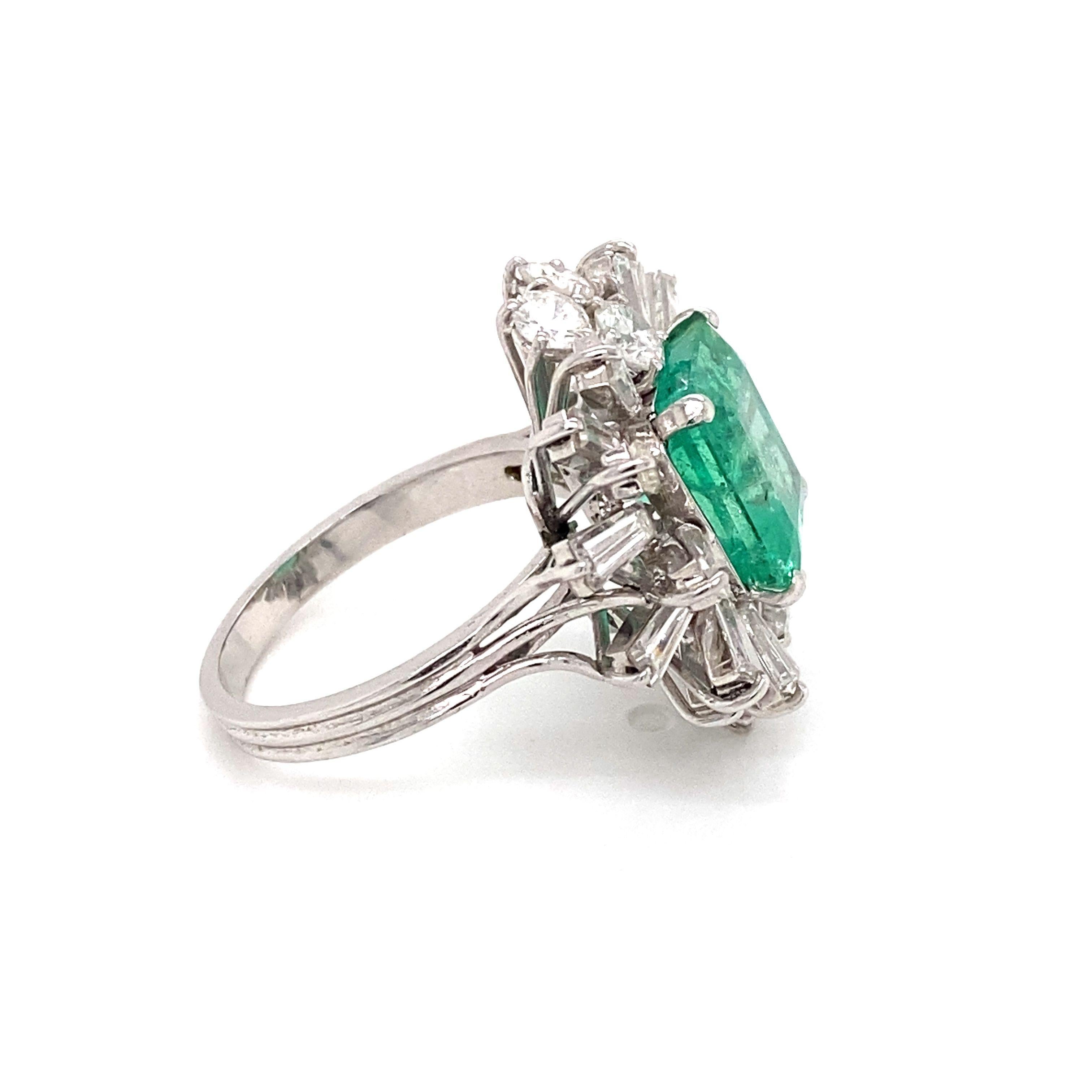 Ein sehr schöner und beeindruckender Ring aus 18-karätigem Gold, besetzt mit einem natürlichen, lebhaften kolumbianischen Smaragd von 5,20 Karat, umgeben von 6 funkelnden runden Diamanten im Brillantschliff und 18 Diamanten im Trapezschliff an den