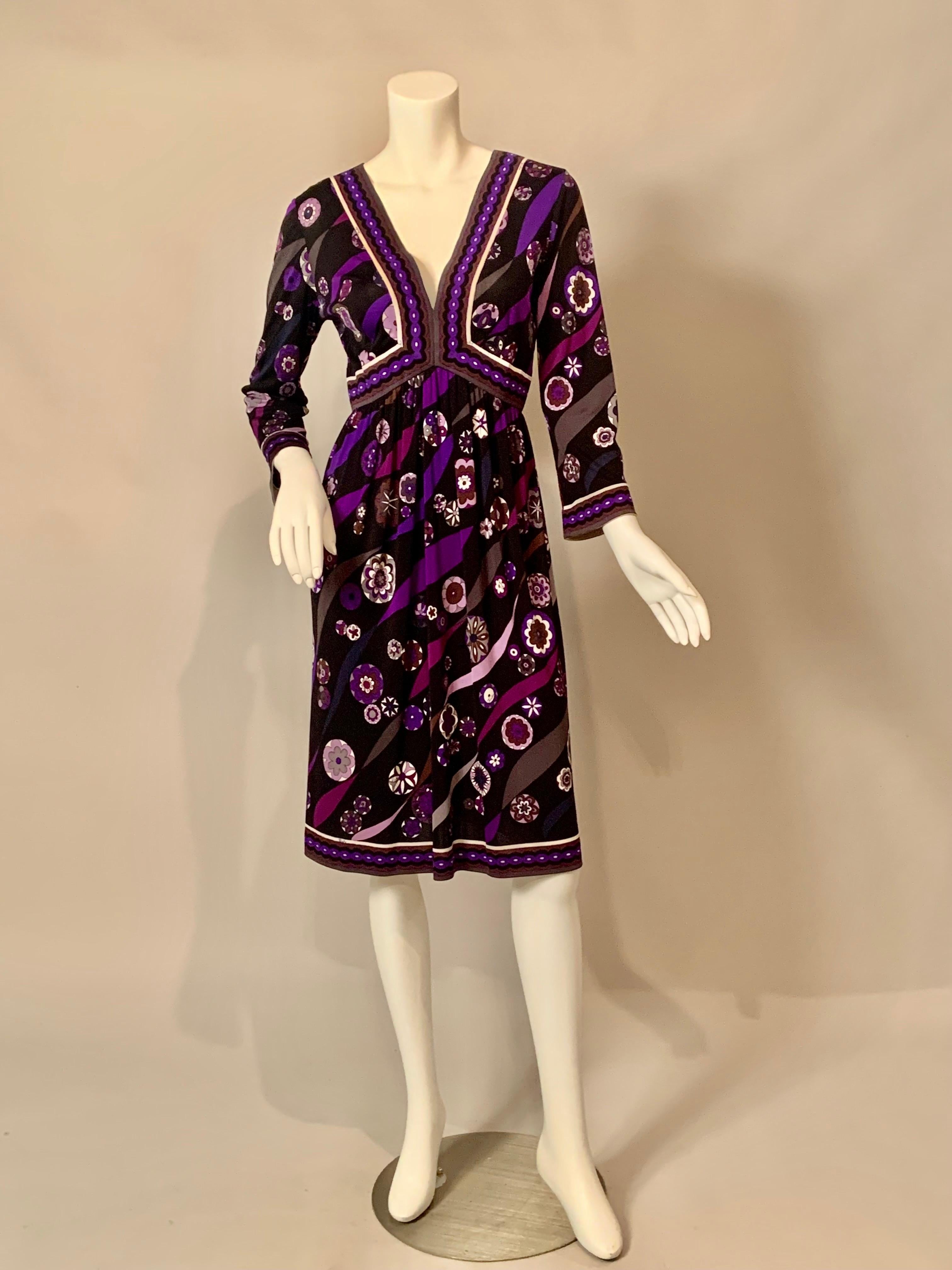 This dress is a wonderful combination of purple, grey, brown, black, white and lavender in a signature Pucci print.  It has a V neckline, and Empire waist, long sleeves and a gathered skirt. There is a metal zipper at the center back dating it to