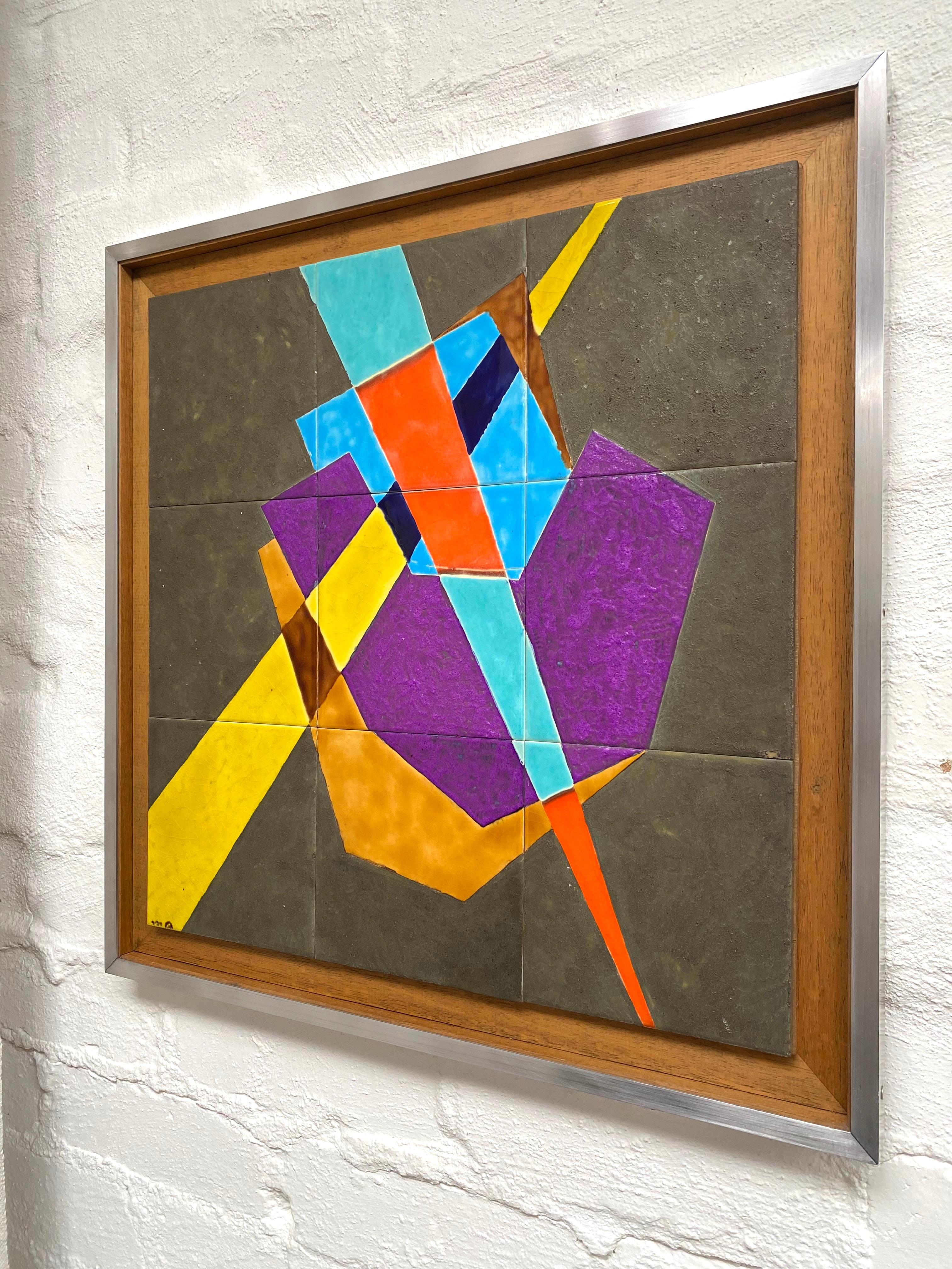 An attractive abstract decorated tile artwork, framed in hardwood and brushed aluminium. Signed by Rachel Savir, ceramicist, active Israel 1970s. 

Bold colours in thick textured and glossy glazes are emblazoned on a set of nine tiles to form an