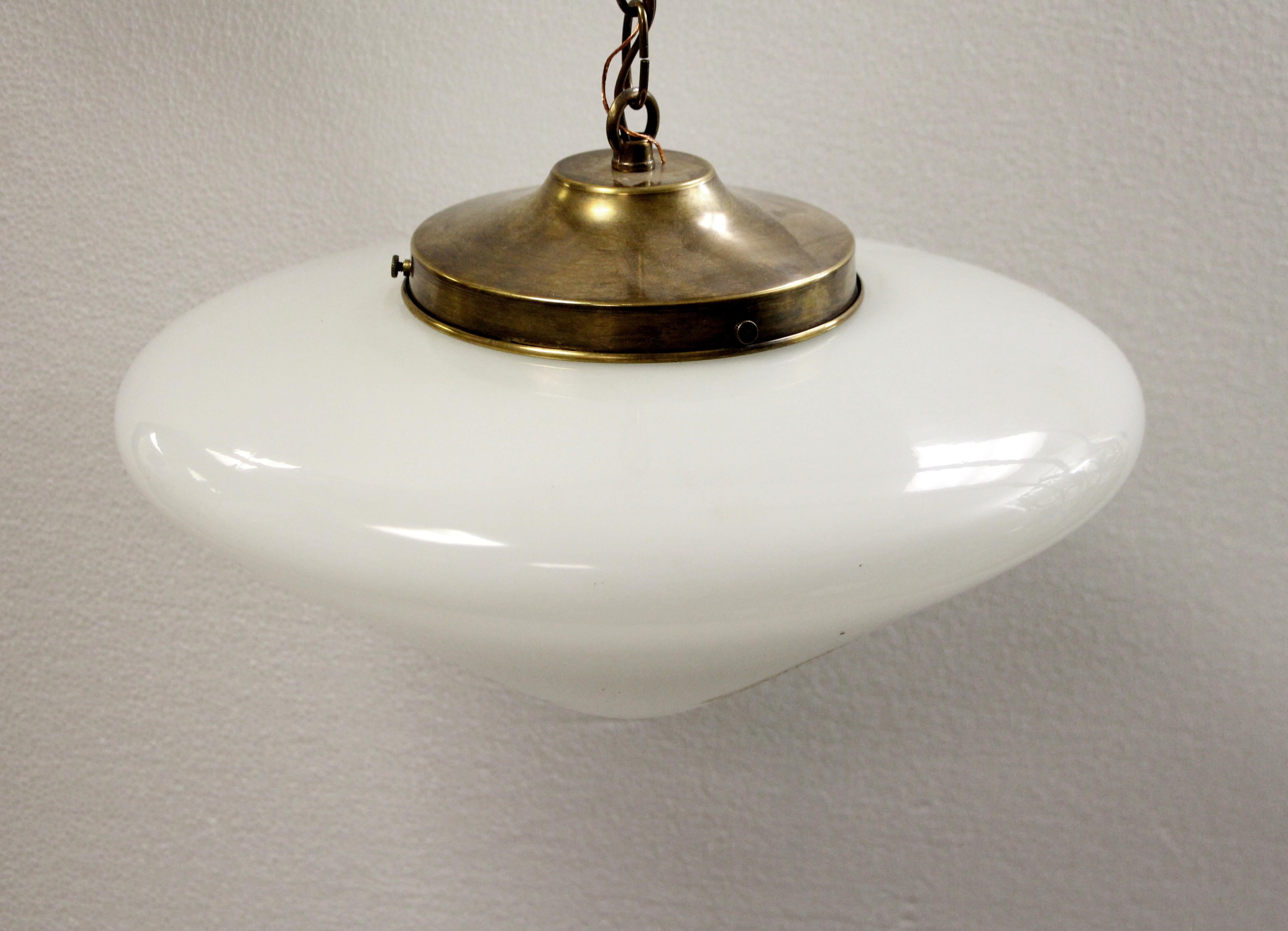Cone shaped white milk glass globe with an antique brass reproduction fitter with chain from the 1970s. This can be seen at our 400 Gilligan St location in Scranton, PA.