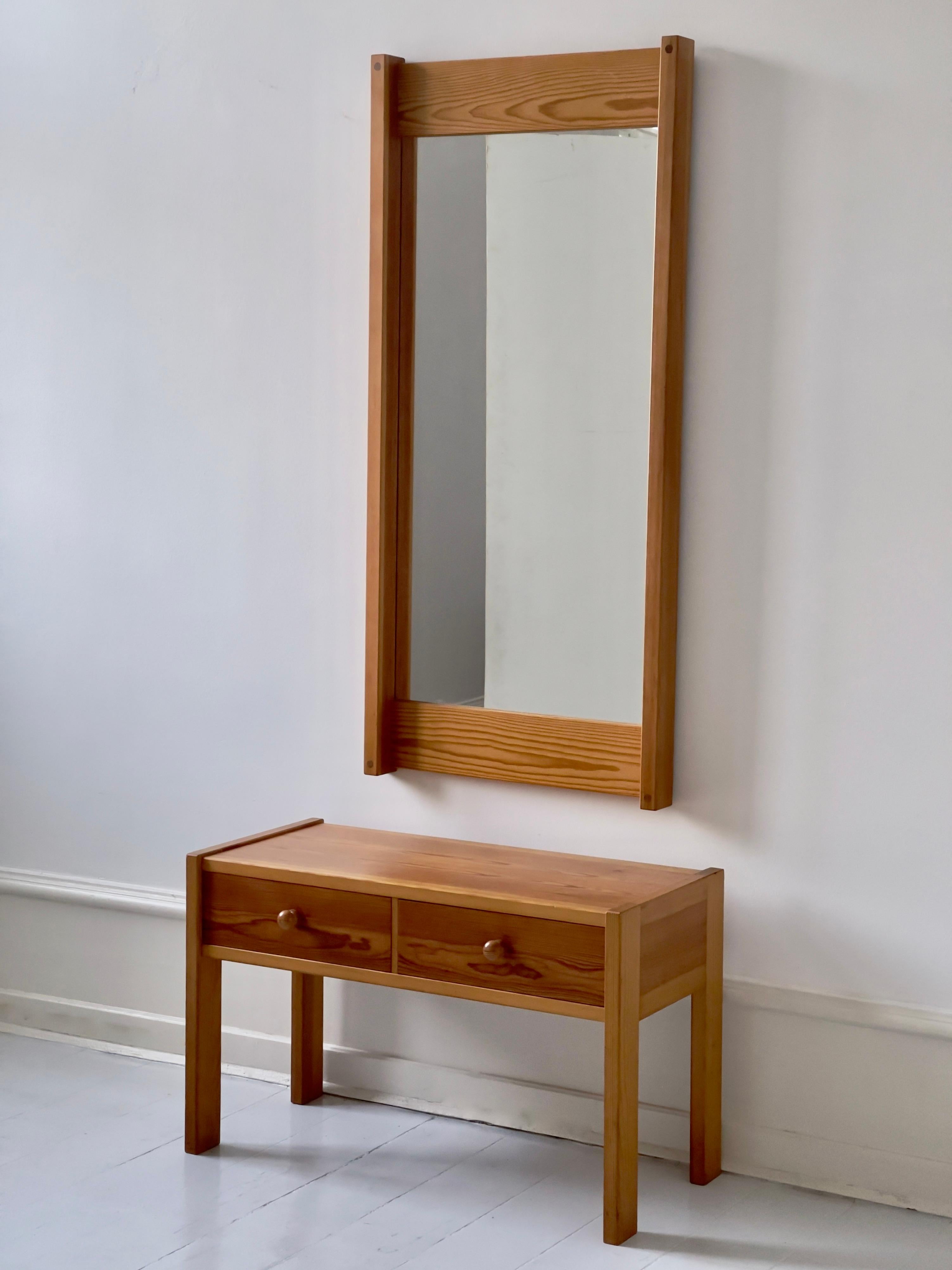 Rare Danish 1970s set of mirror with console in solid pine. Beautifully crafted by Aksel Kjersgaard in Odder, Denmark. The mirror and console is created as a set and holds a rich and evenly patinated color coming from the premium selection of old