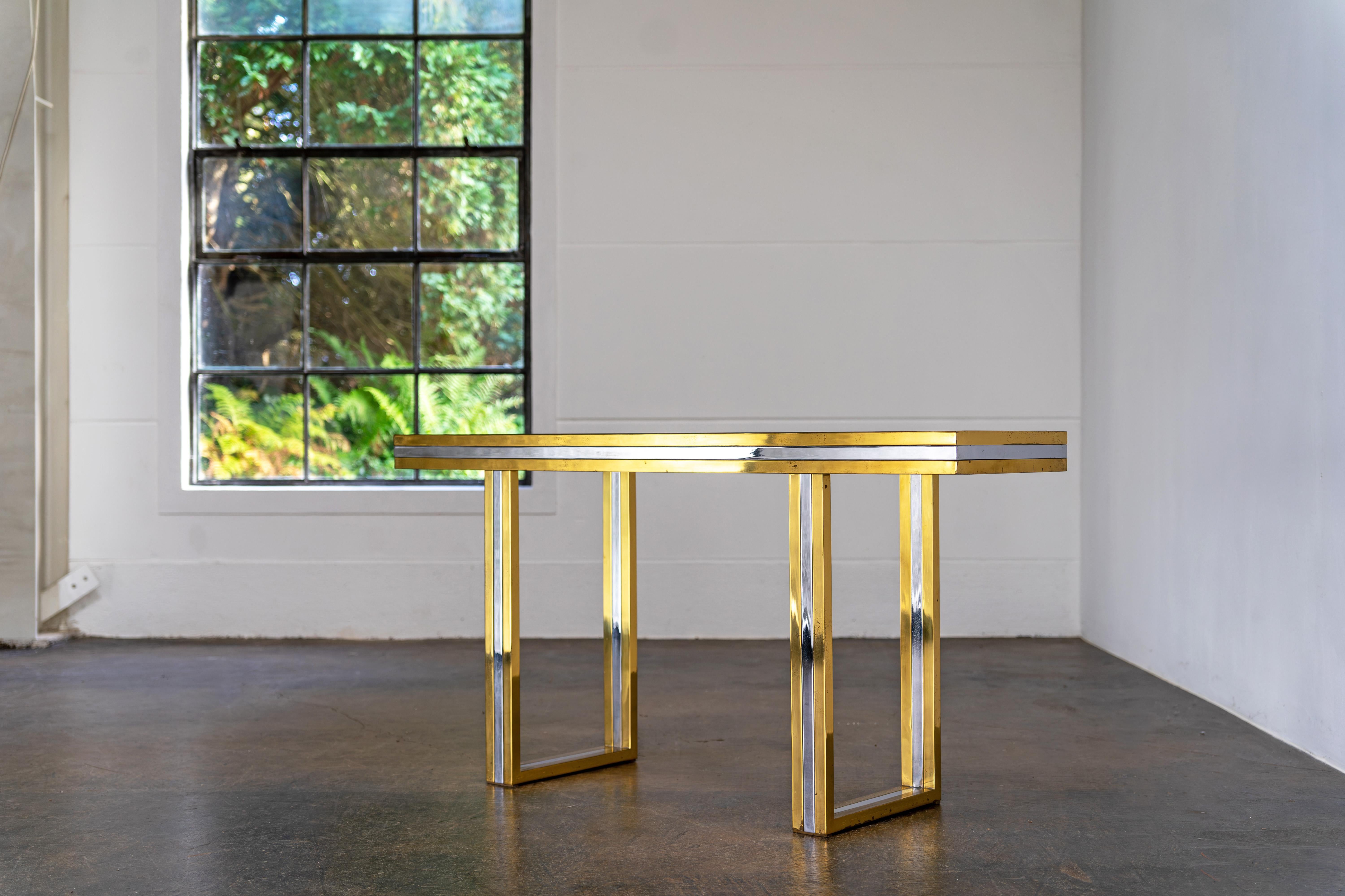 Romeo Rega attributed console table from the 1970s. Beautiful bi-color chrome and brass console table with a glass top. The piece shows patina on the brass. 

We can organize fast shipping for competitive prices. Please contact us for info to your