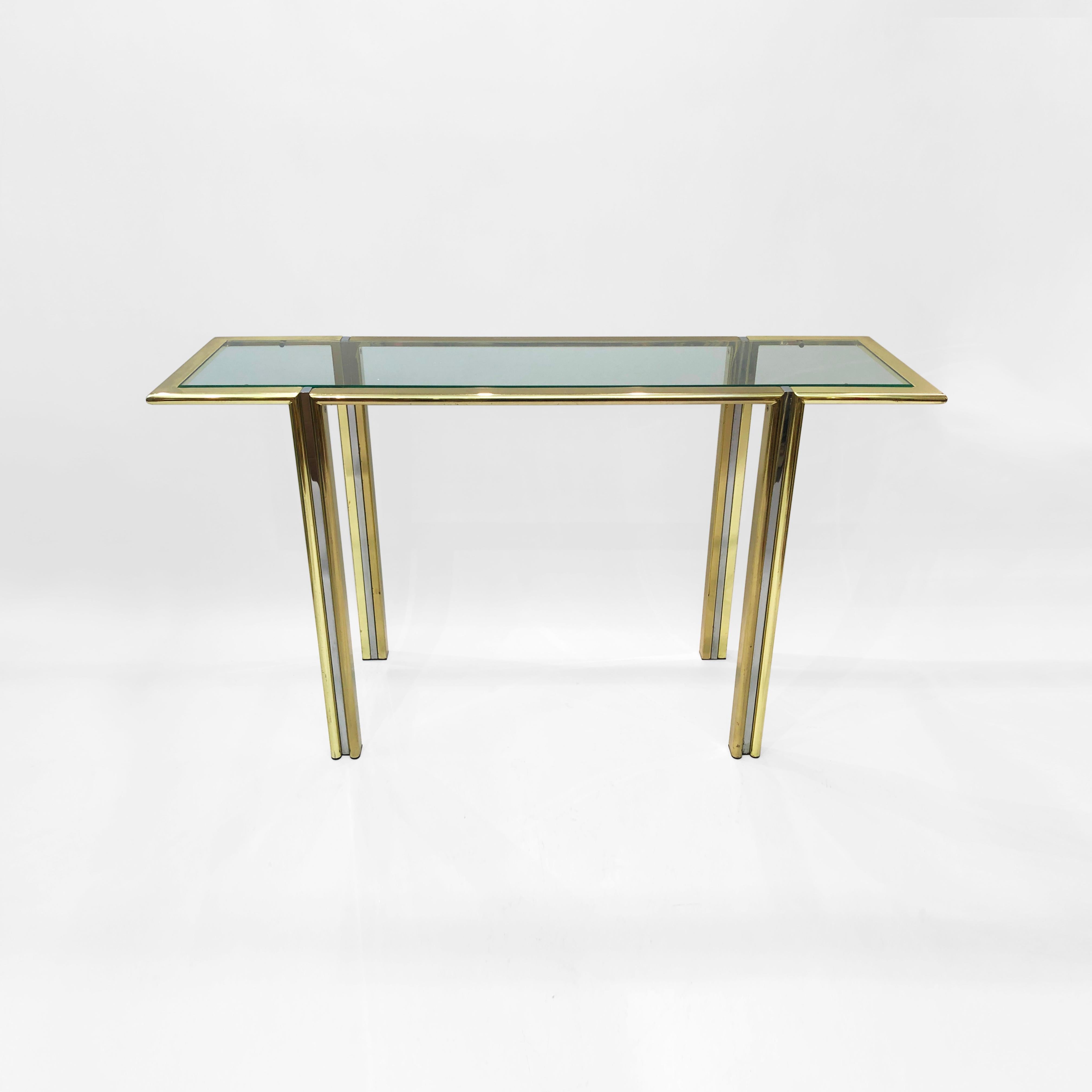 A stunning chrome and gold-plated console table, originally from Milan in the 1970s. Bullnosed metal, plated in gold, connect at four chrome legs. A pane of clear glass rests atop the structure. This piece is unique in that the legs are outflanked