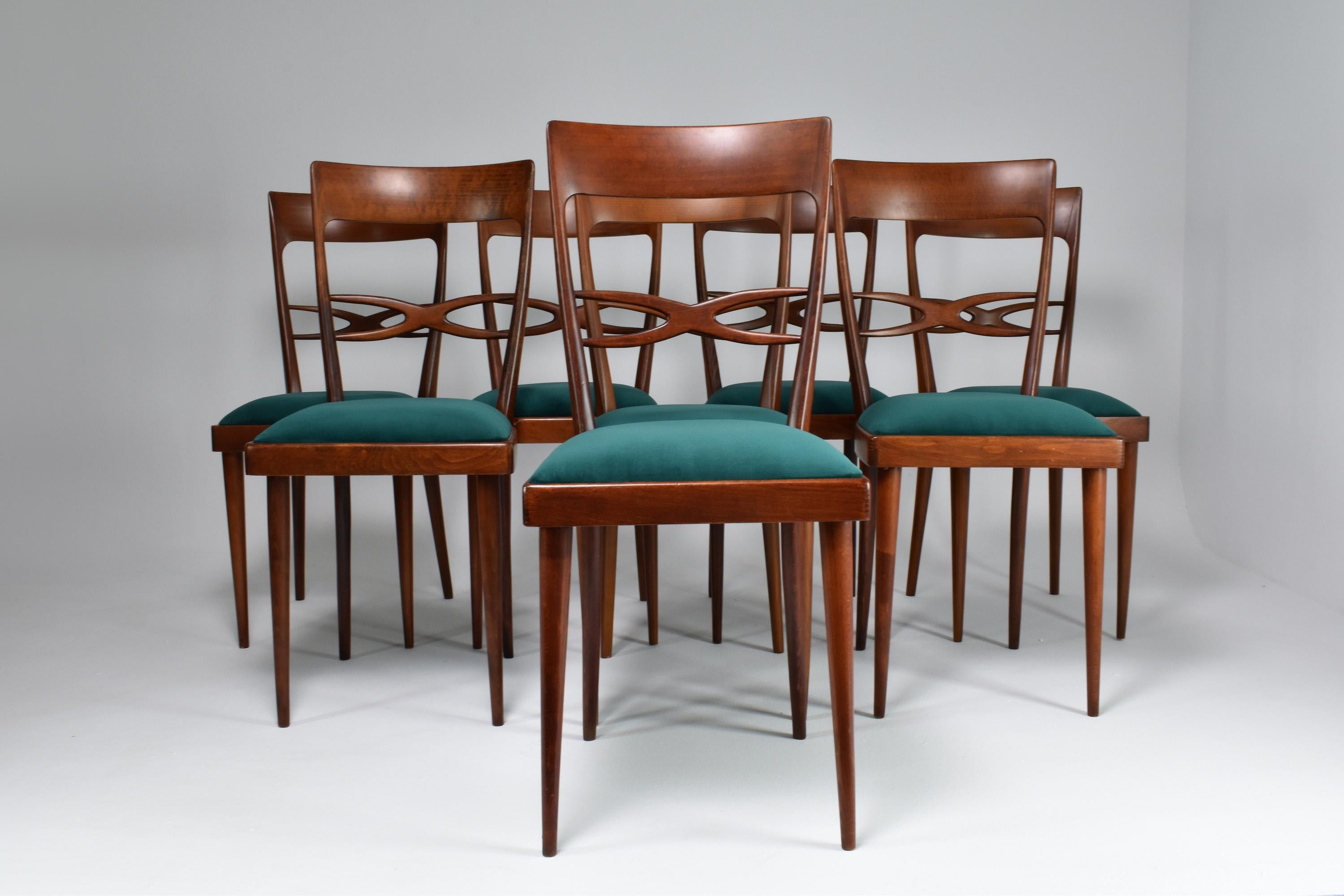 Magnificent set of 8 Italian Mid-Century Modern beechwood dining chairs designed by Consorzio Sedie Friuli in expertly restored condition with new padding, upholstery, and refinishing. 
This collectible set is highlighted by the beautifully