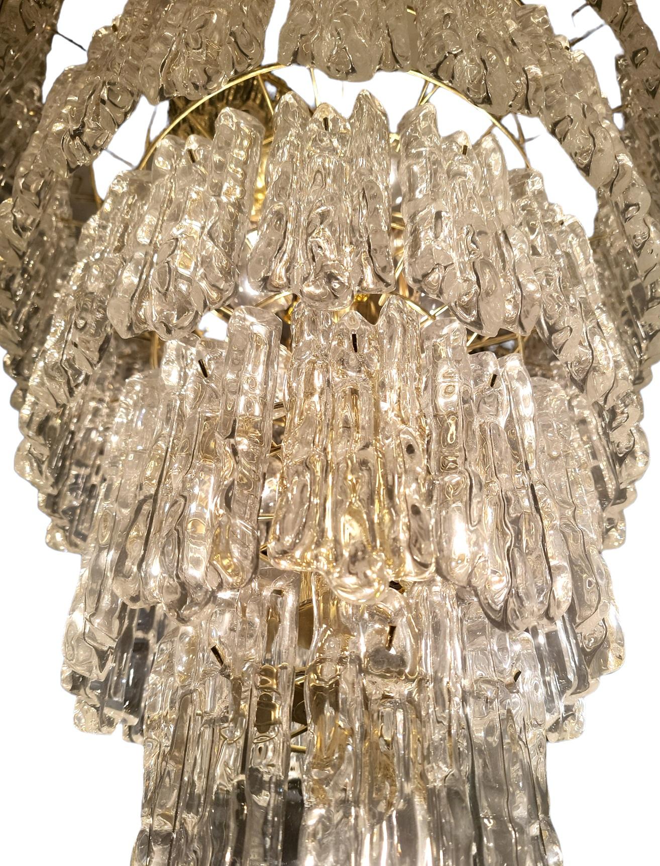 Contemporary Modern 5 tier Brass and lucite hanging chandelier. The lucite waterfall design on this chandelier has a circular design for each tier. each lucite piece has a 3 vertical lucite look. Each piece looks as if there are 3 pieces of luctie