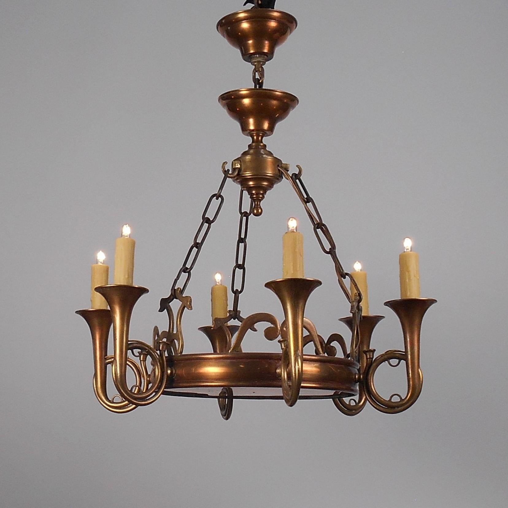 Presented is a copper and brass chandelier featuring six bugle arms with 4