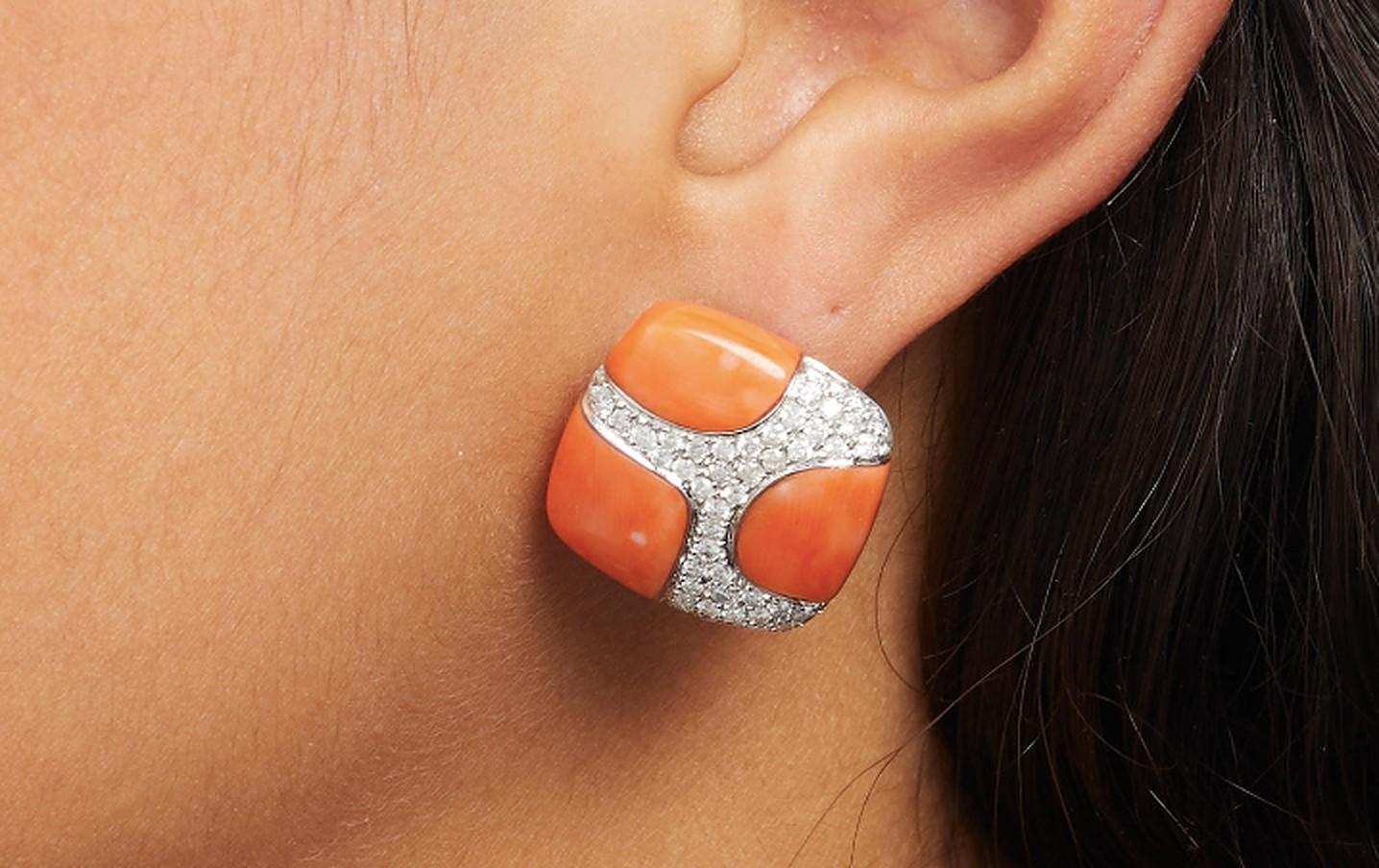 Ravissante paire de boucles d'oreilles en corail et diamant, rehaussées de 1,20 carats de diamants dans un motif tourbillonnant. Fabriqué en Amérique, vers 1970.