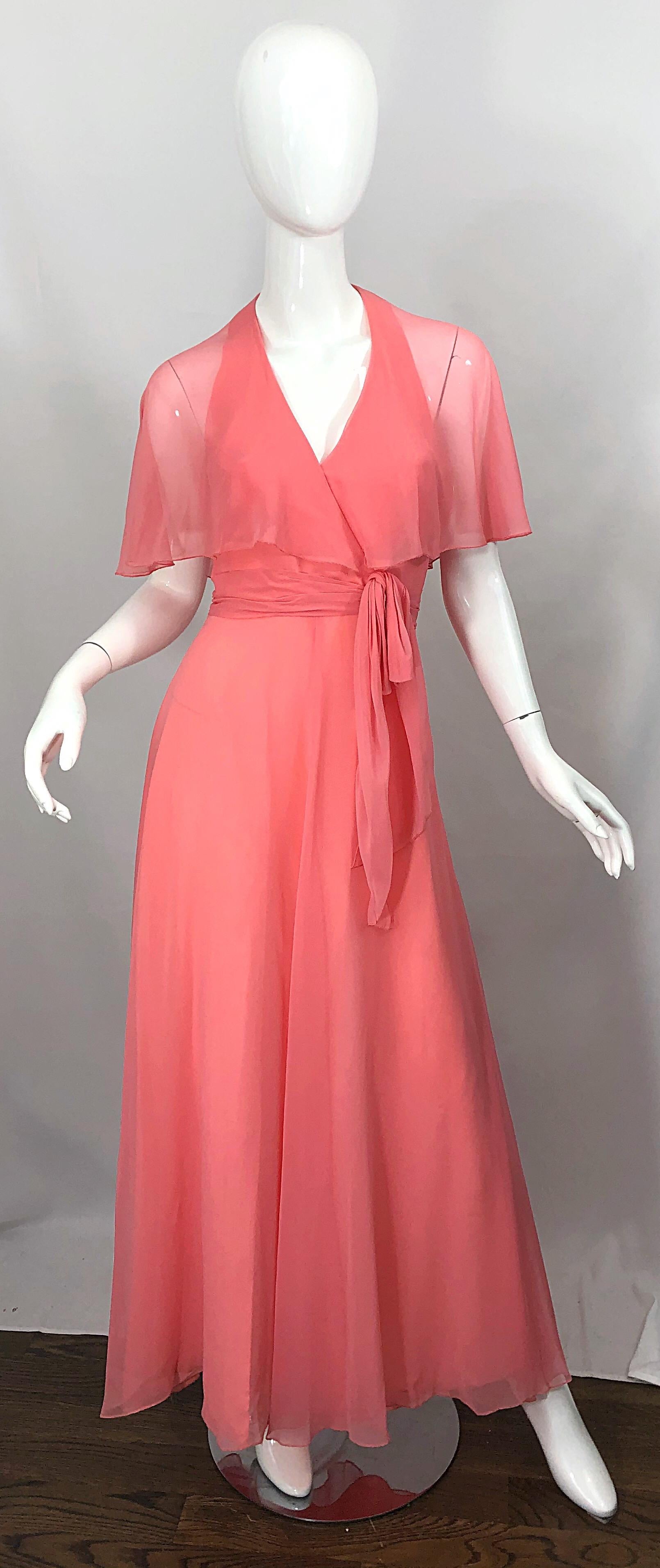Beautiful 1970s coral pink halter maxi dress / gown with attached sheer caplet! Features a halter neck with two spaghetti straps in the back to offer additional support. Self tied sash belt at left waist. Tailored bodice with a full skirt. Hidden