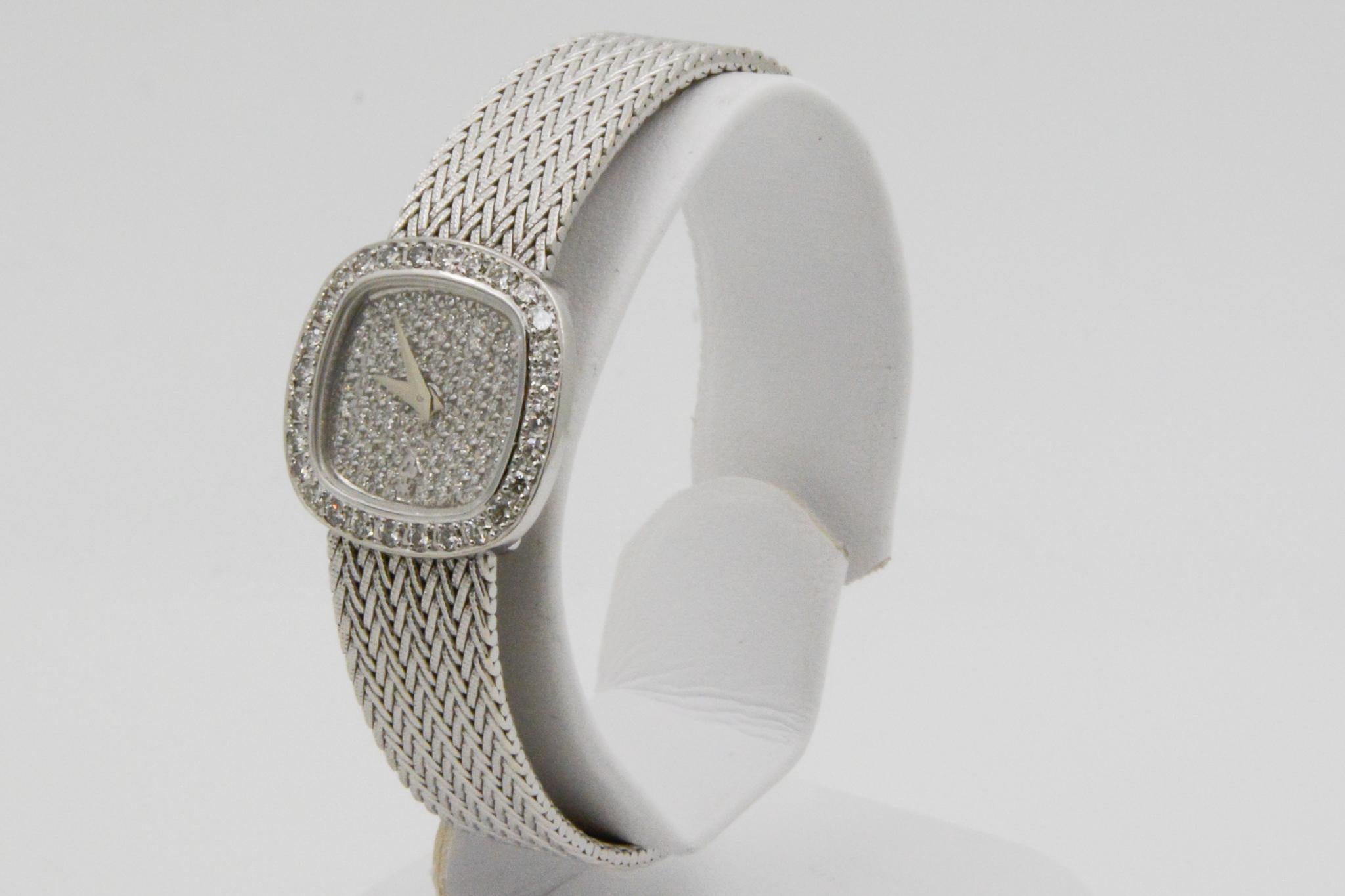 Model: Corum Diamond Watch #14234.69P57
Movement: Manual Wind 
Case Material: 18k White Gold 
Dial: Cushion Shape Pave Diamond, Round Brilliant Cut Diamond Bezel 
Strap: Five Row Mesh 
Circa 1970, No box, No papers