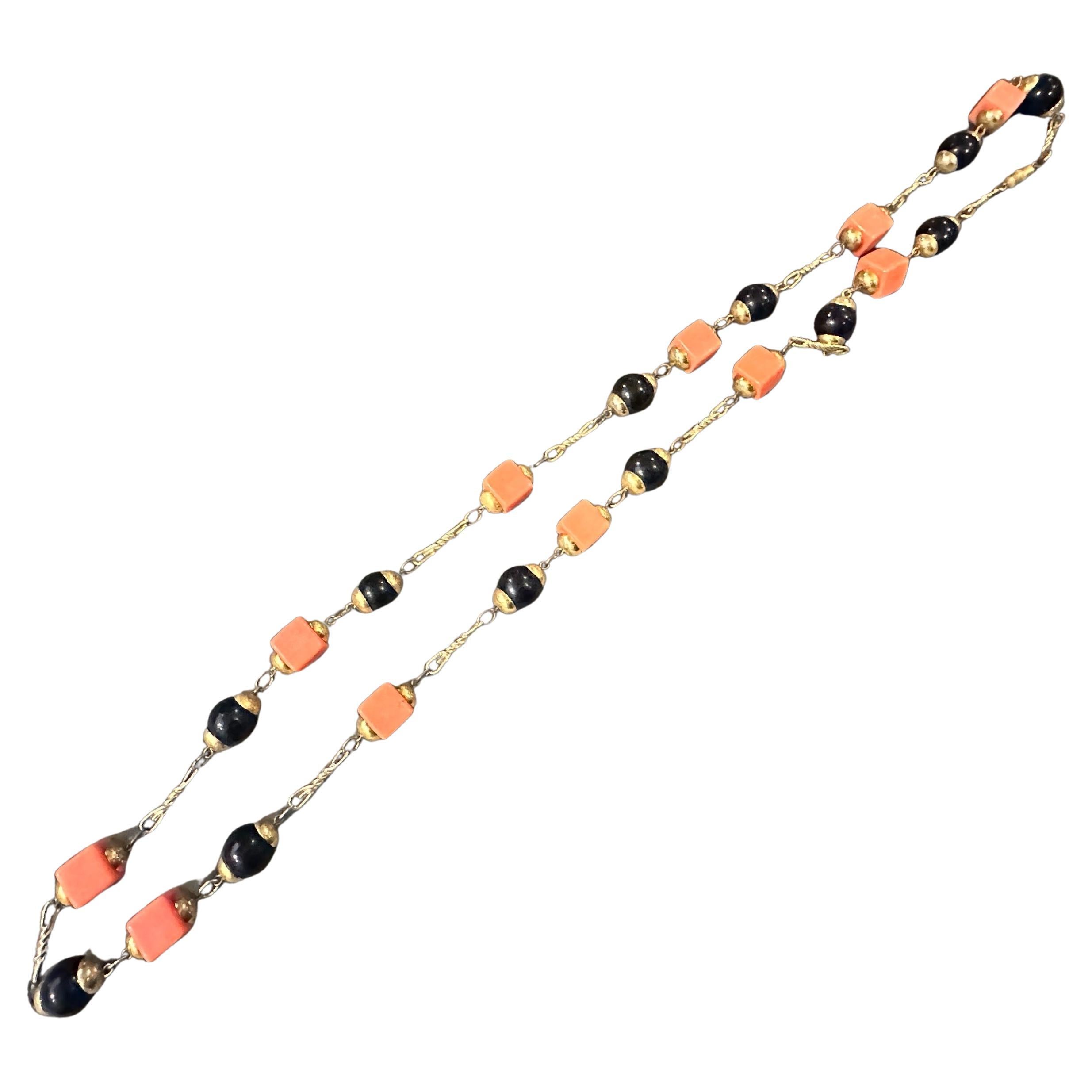Il s'agit d'un collier de bijoux fantaisie italiens vintage des années 1970, un bel exemple de l'utilisation audacieuse des couleurs et des formes géométriques de l'époque. La pièce présente un motif alternant des perles noires lisses, rondes à