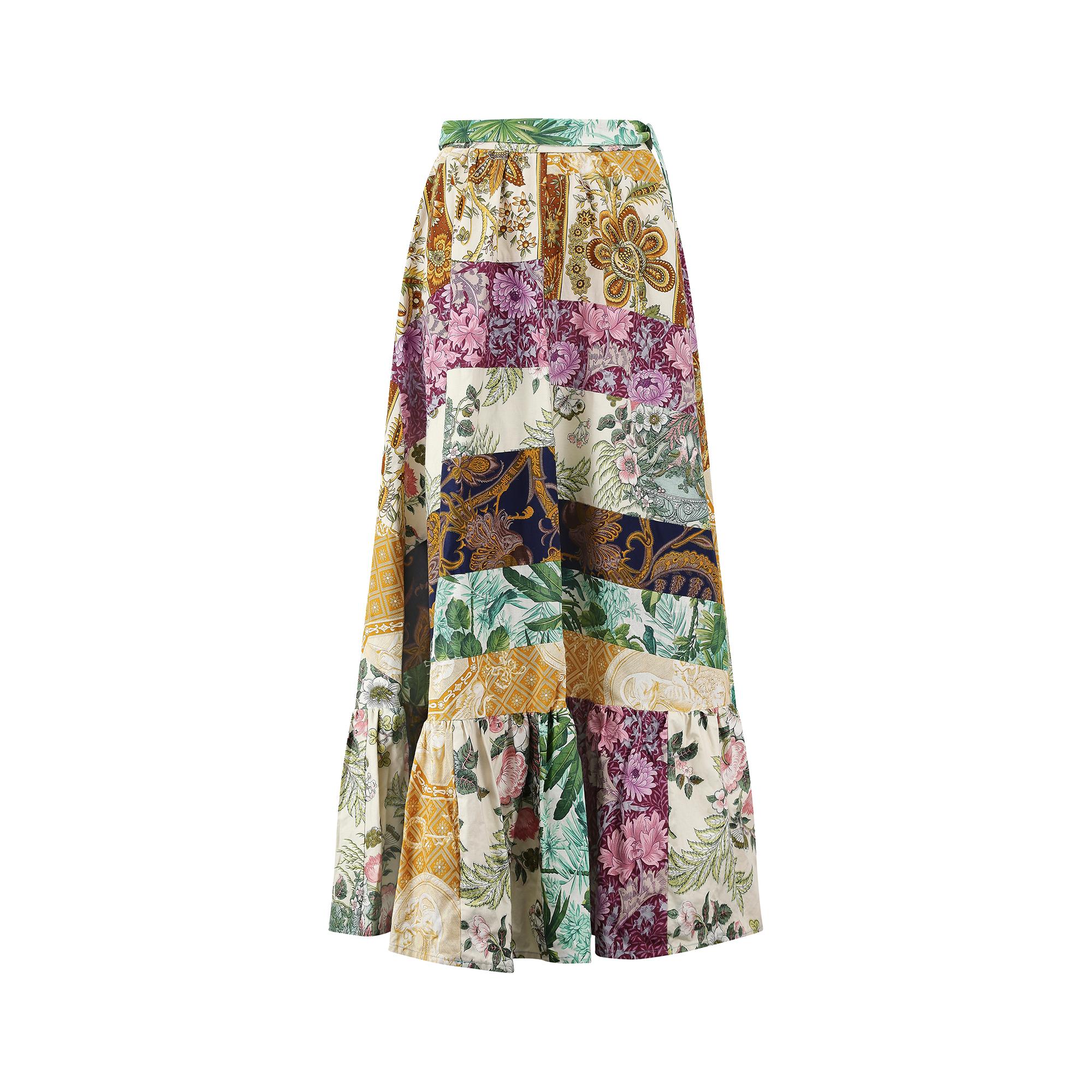 This 1970s a-line maxi skirt is constructed from a thick cotton patchwork of larger multicoloured patchwork panels.  These are composed of delicate floral designs in varying shades of green, purple, navy and earth-coloured tones.  as the fabric is