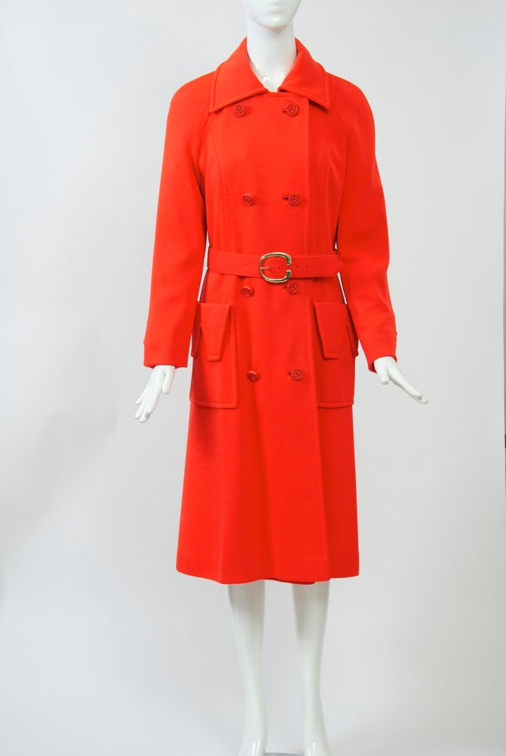 Count Romi era specializzato in cappotti per tutte le stagioni e in cappotti adatti ai viaggi. Questo esemplare, risalente ai primi anni '70, è realizzato in maglia di lana rosso brillante e presenta uno stile a doppio petto, profonde tasche