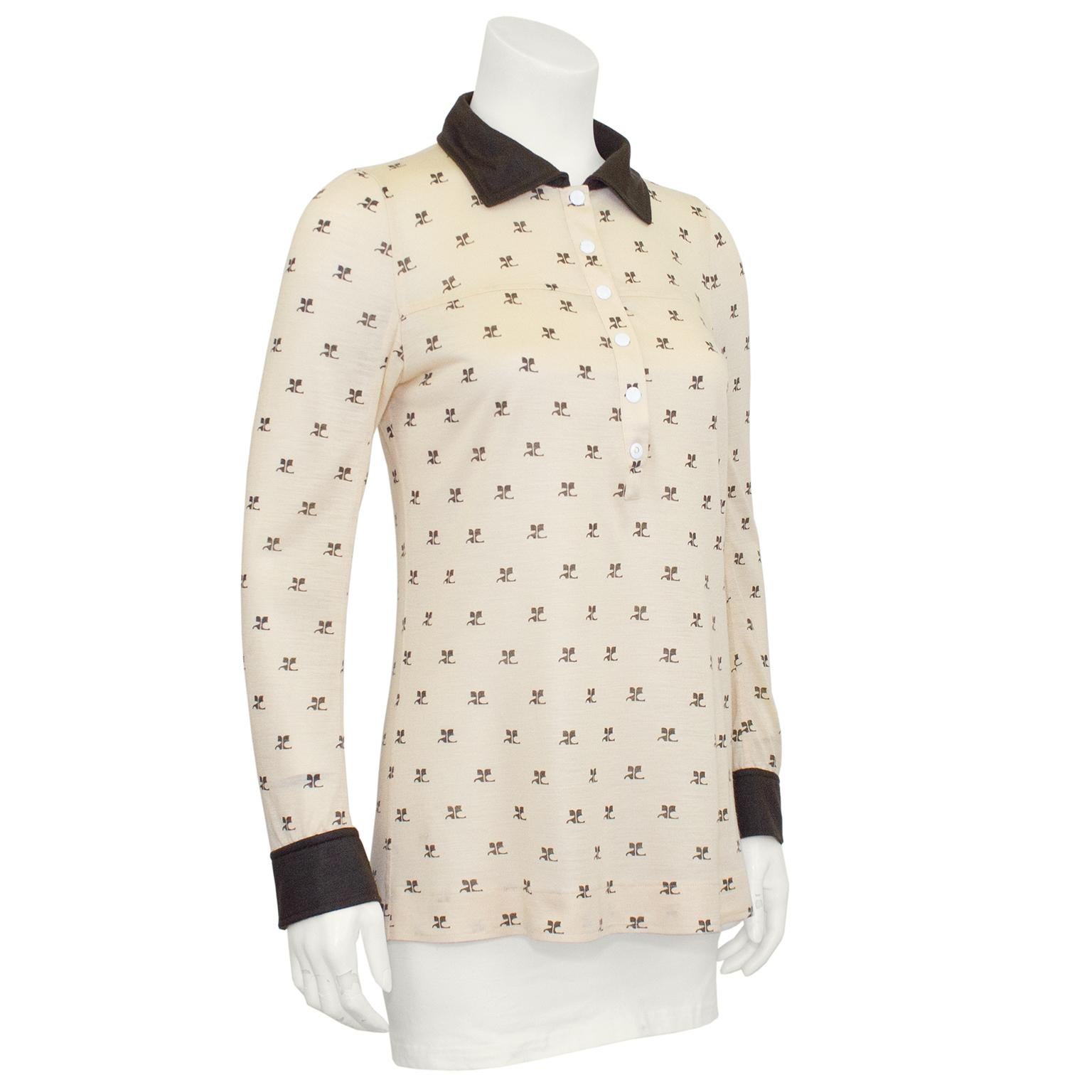 Join the logo mania trend with this very cute Courreges long sleeve henley from the 1970s. Beige cotton chocolate brown Courreges logos and chocolate brown collar and cuffs. Contrasting white snap buttons at neckline and cuffs. Overall good vintage