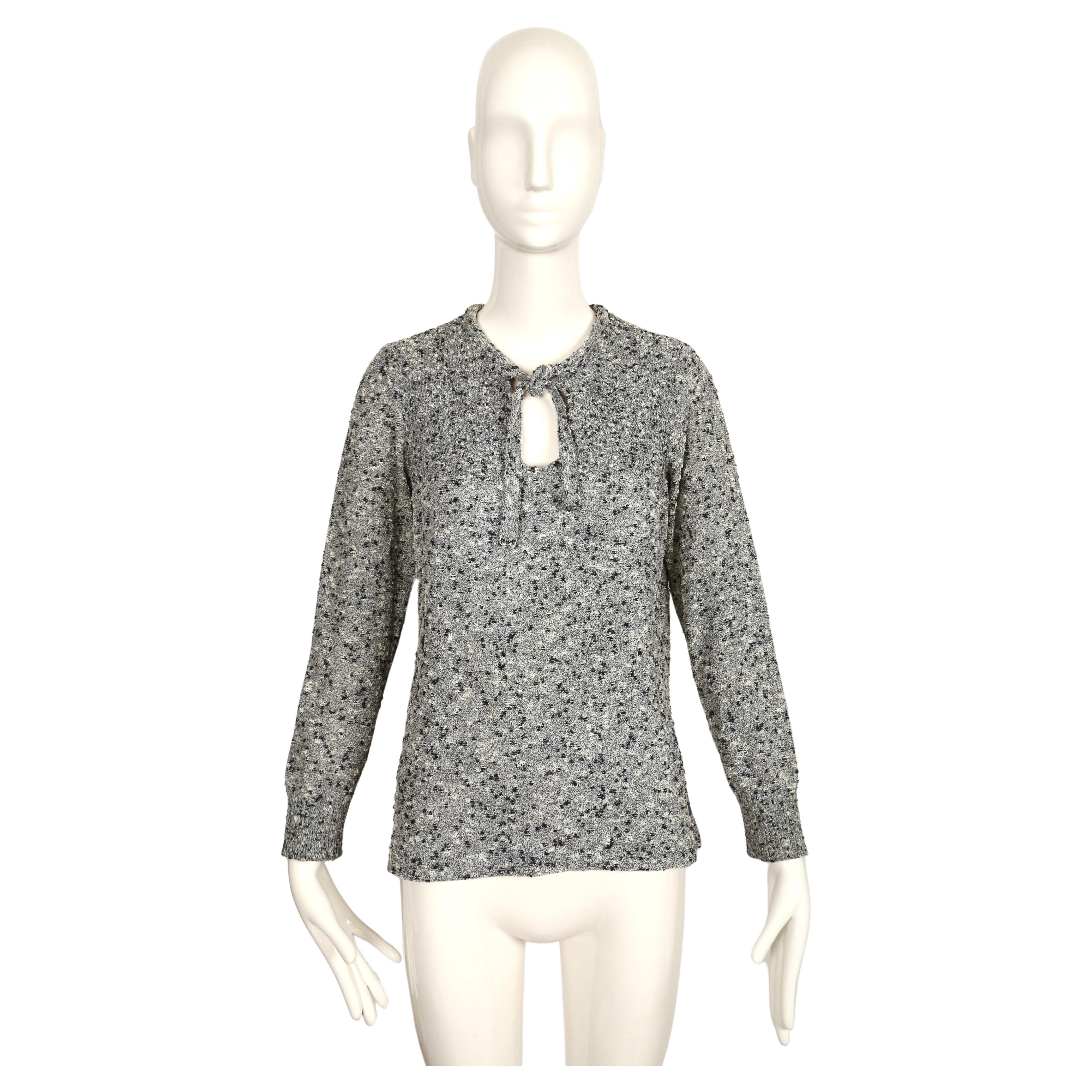 Black and off-white boucle knit tunic with neck tie designed by Courreges dating to the 1970's. Pointelle knit at collar area. Labeled a size C which best fits a M.  Approximate measurements (un-stretched): shoulder 1