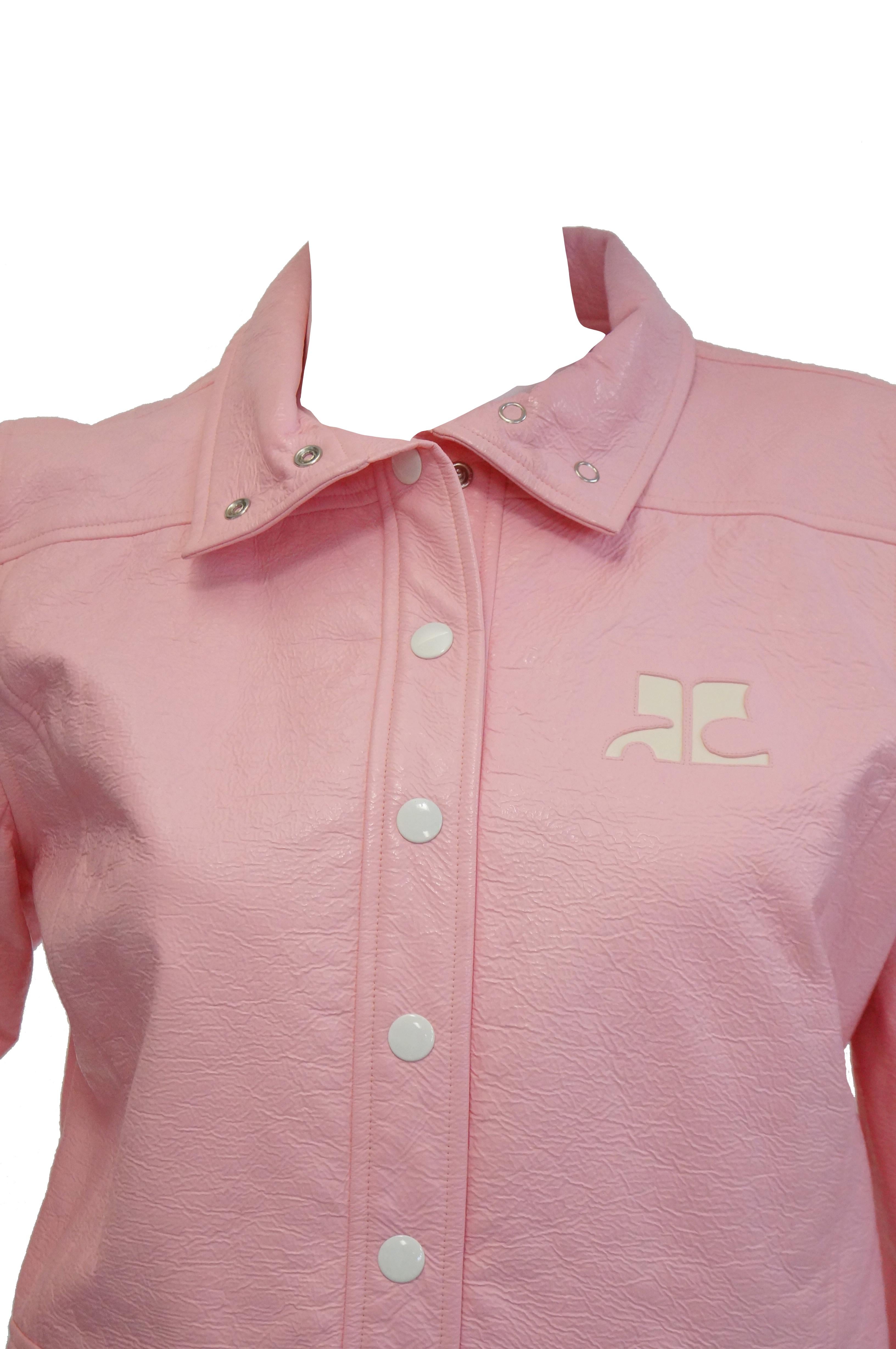Awesome bubblegum pink 1970s jacket by Courreges! The jacket is cropped, with long sleeves, a high neck collar, and a loose and boxy fit typical of late 1970s Courreges. The iconic Courreges logo features prominently in white vinyl on the left