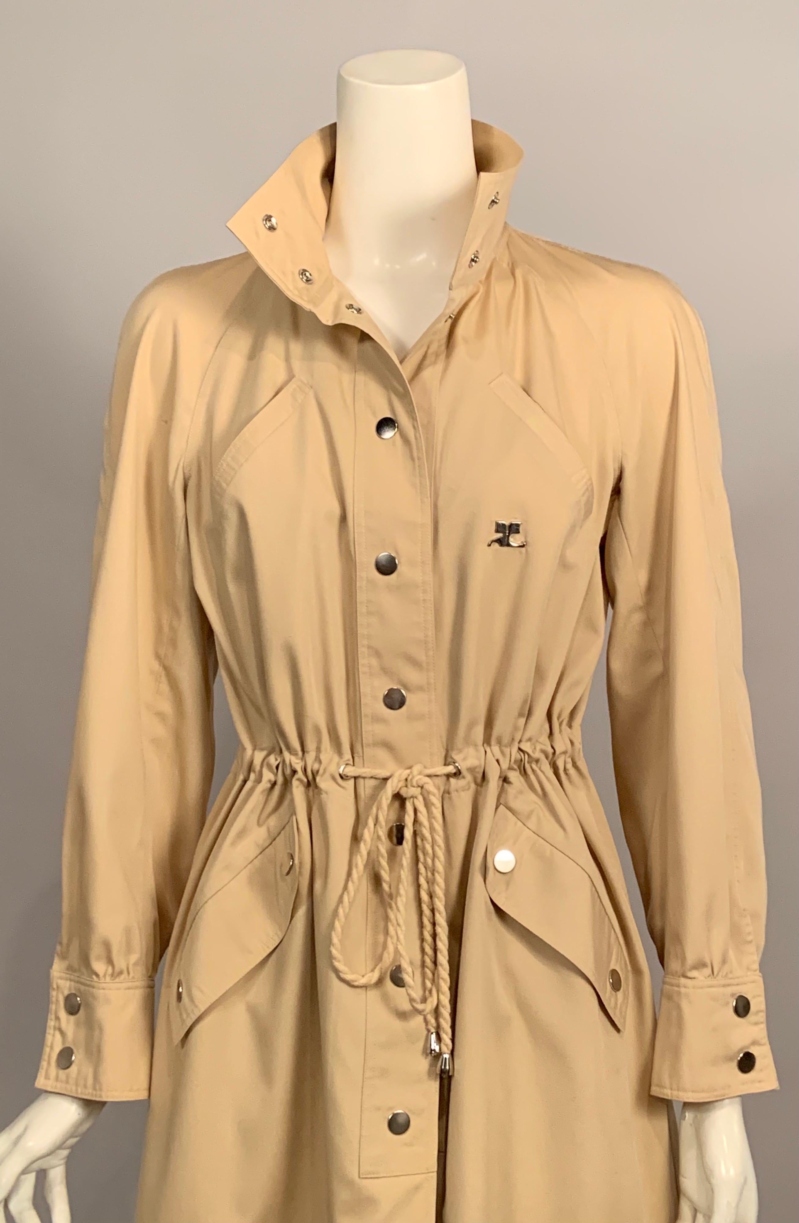 Rain or shine this tan cotton coat designed by Andre Courreges in the 1970's is just perfect.  The funnel neck can be closed with two snaps. There are two breast pockets placed on the diagonal above a drawstring waist. There are two more diagonal