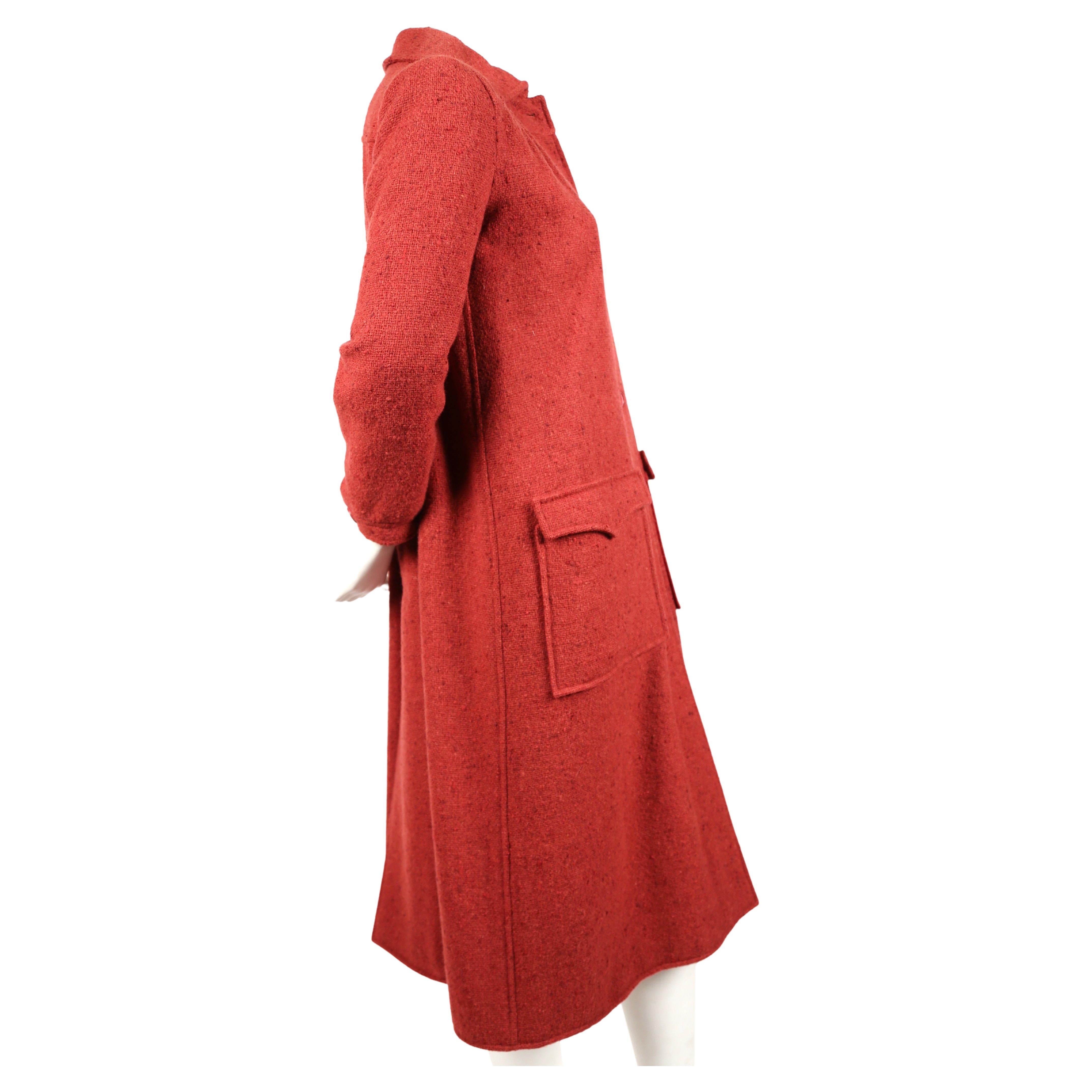 Raspberry colored nubby textured wool coat from Courreges dating to the 1970's. The coat fits narrow through the shoulders/arms and falls loose from the bust down to hemline. Labeled a size '00', which best fits a US 4 or 6. Approximate measurements