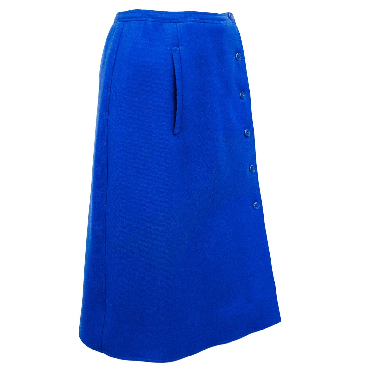 Stunning and classic Courreges bright, royal blue wool gabardine skirt from the 1970s. Aline, wrap style with six matching small plastic blue buttons down the left side while wearing. Single slit pocket on left side. Matching blue lining and 2.5