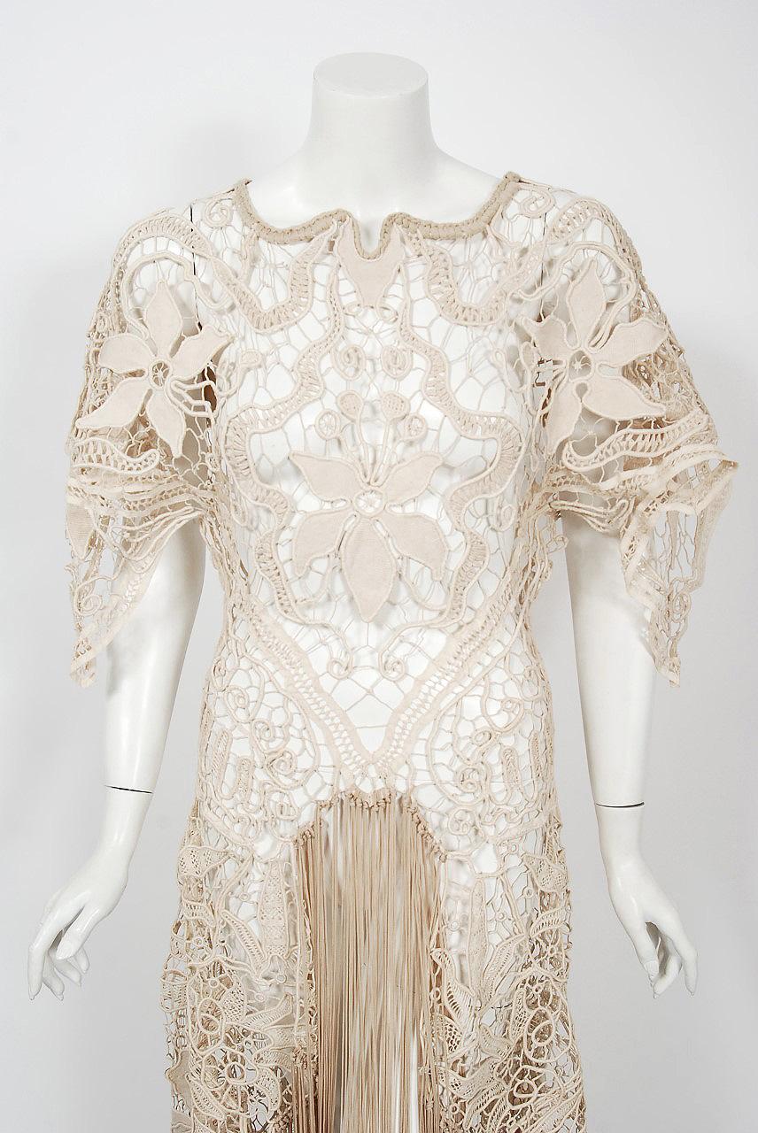 An ethereal 1970's British custom couture sheer lace gown that effortlessly mixes the bohemian vibe with 1930's Old Hollywood glamour. The fabric used is breathtaking; hand finished floral motif corded beige tape lace which molds to the body with