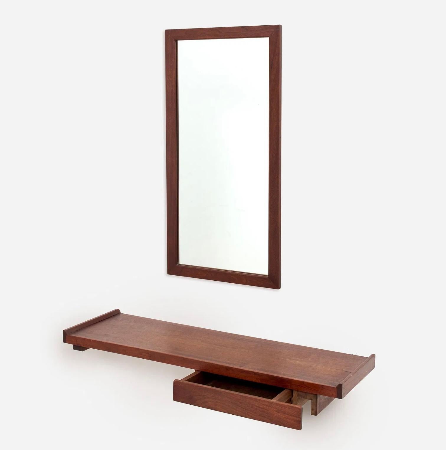 A nice American Craftsman Walnut Wall shelf and Mirror. The wall shelf has one drawer underneath. This is not a commercial piece and is hand made. Please see the detail photos. It is crafted out of Walnut. The shelf is approximately 39” long by 12