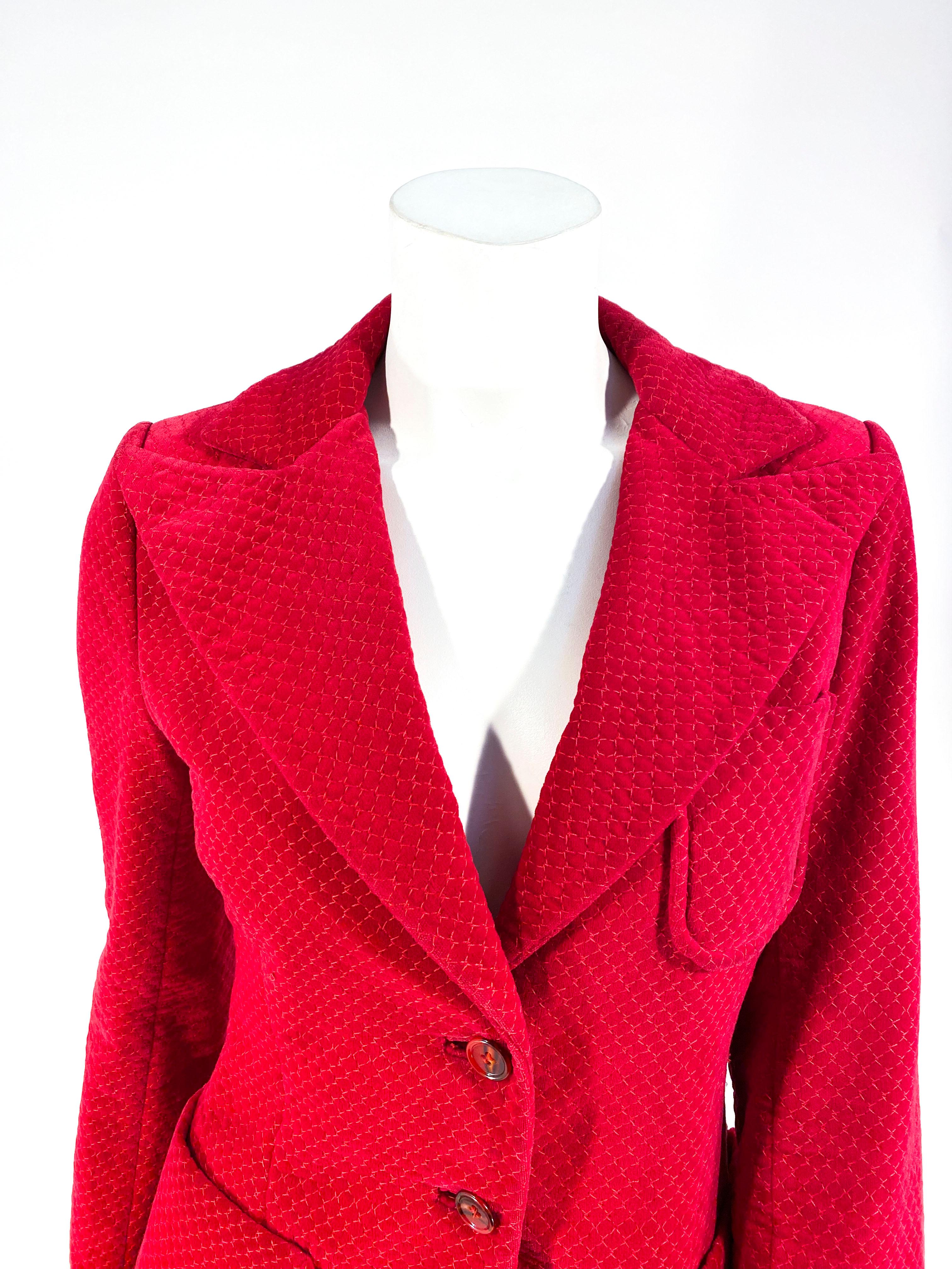 1970s Cranberry red patterned velvet blazer with a large peak lapel collar, two large patch pockets, and one small patch pocket an the bust. The interior is fully lined and the face as two red faux tortoise buttons. 