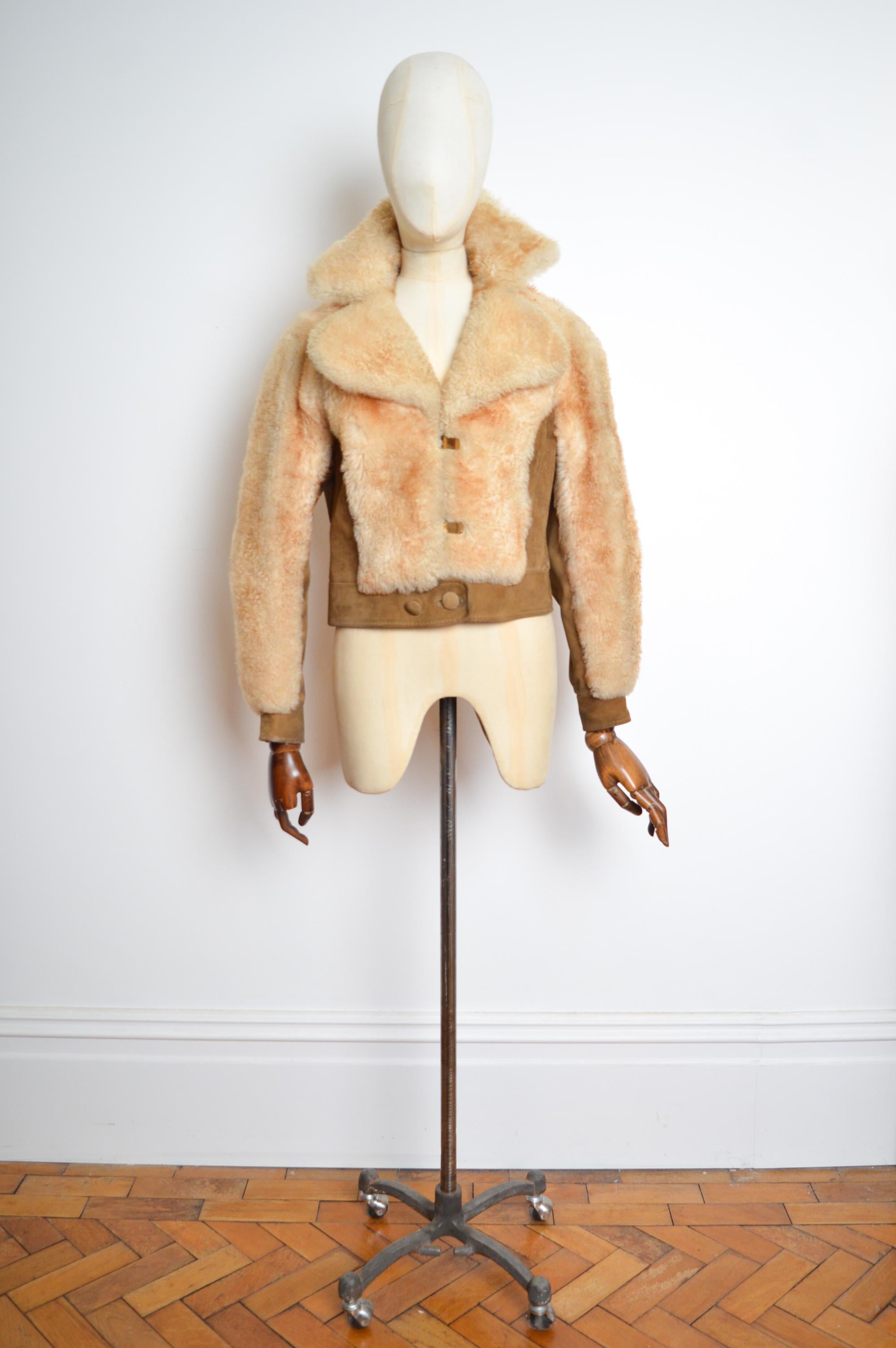 Cream Sheepskin Exterior intercepted with tan suede panels and brass hardware. Interior is rayon lined.
Pit to Pit; 18.5”
Pit to Cuff; 18” 
Nape to Hem; 21.5”
Size; U.K. 8
Condition; 7/10 overall good condition despite age related wear, suede areas