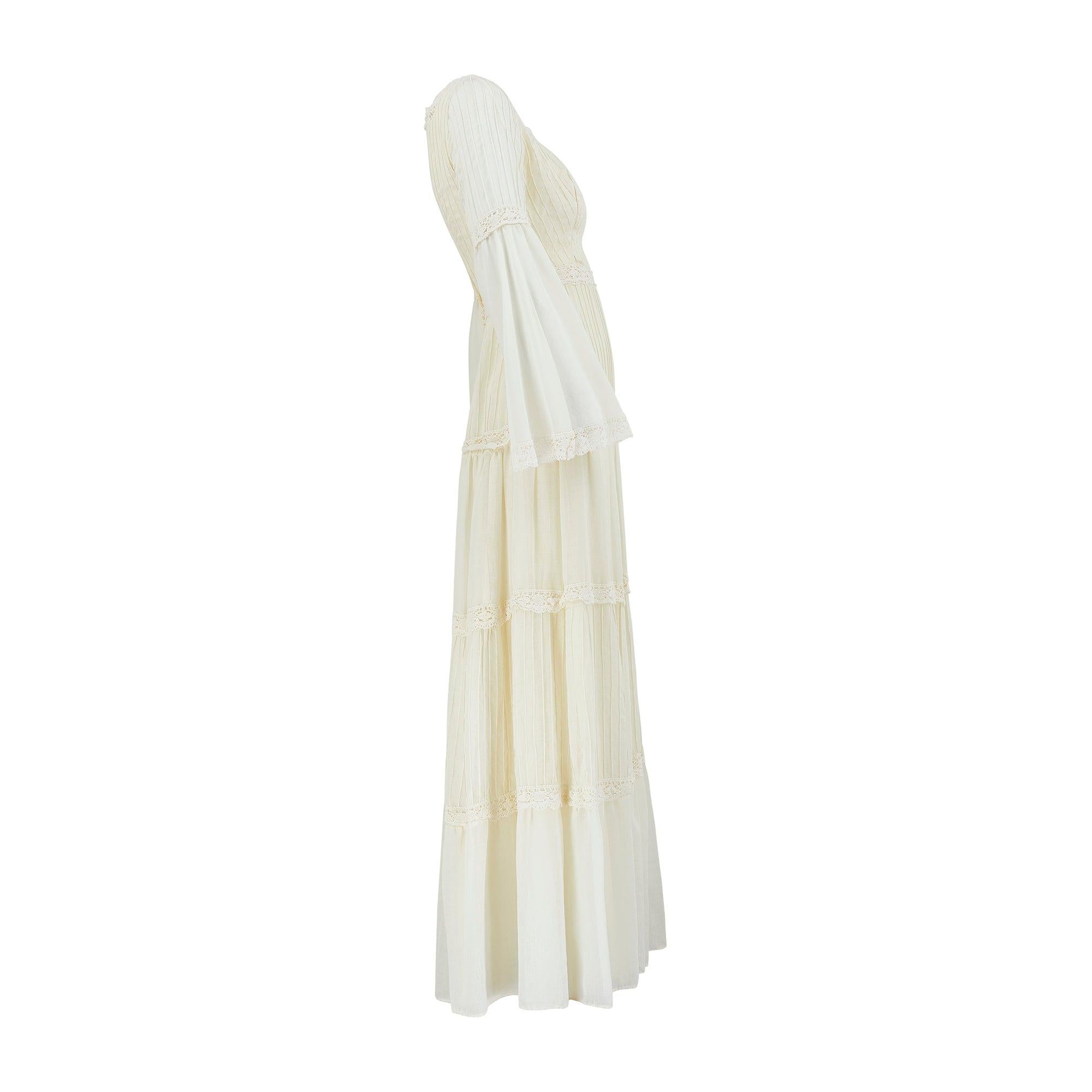This 1970s mousseline cotton dress has many of the hallmarks of traditional Mexican wedding design. It is tailored to a breezy ankle length, A-line silhouette and detailed all-over with tonal pintuck stitching. Horizontal stripes of crochet create