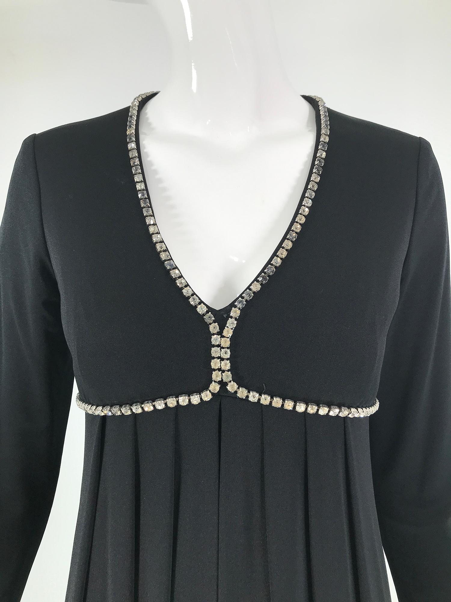 1970er Jahre Kristall Strassbesetztes schwarzes Jersey V-Ausschnitt Maxikleid. Schlankes Kleid, dessen Büste mit Strasssteinen in Zackenfassung umrahmt ist. Das Kleid hat eine Empire-Taille, der Rock ist unter der Büste leicht gerafft und fällt