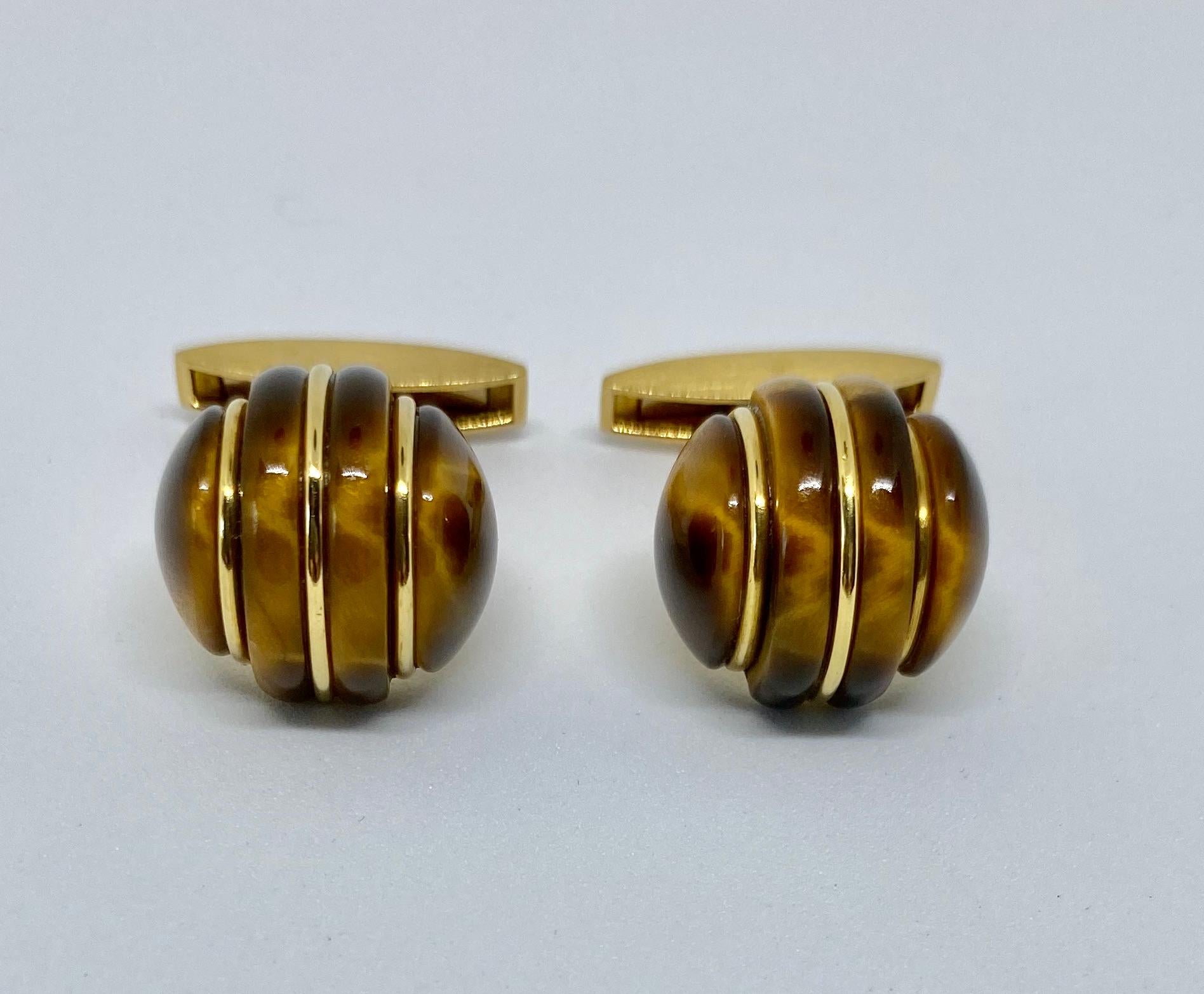 Spectacular, 1970s-era cufflinks made in Germany and featuring two large, carved tiger's eye domes set in 18K yellow gold. The color and quality of the tiger's eye is exceptional, as is the workmanship.

The cufflinks are signed GERMANY and 750