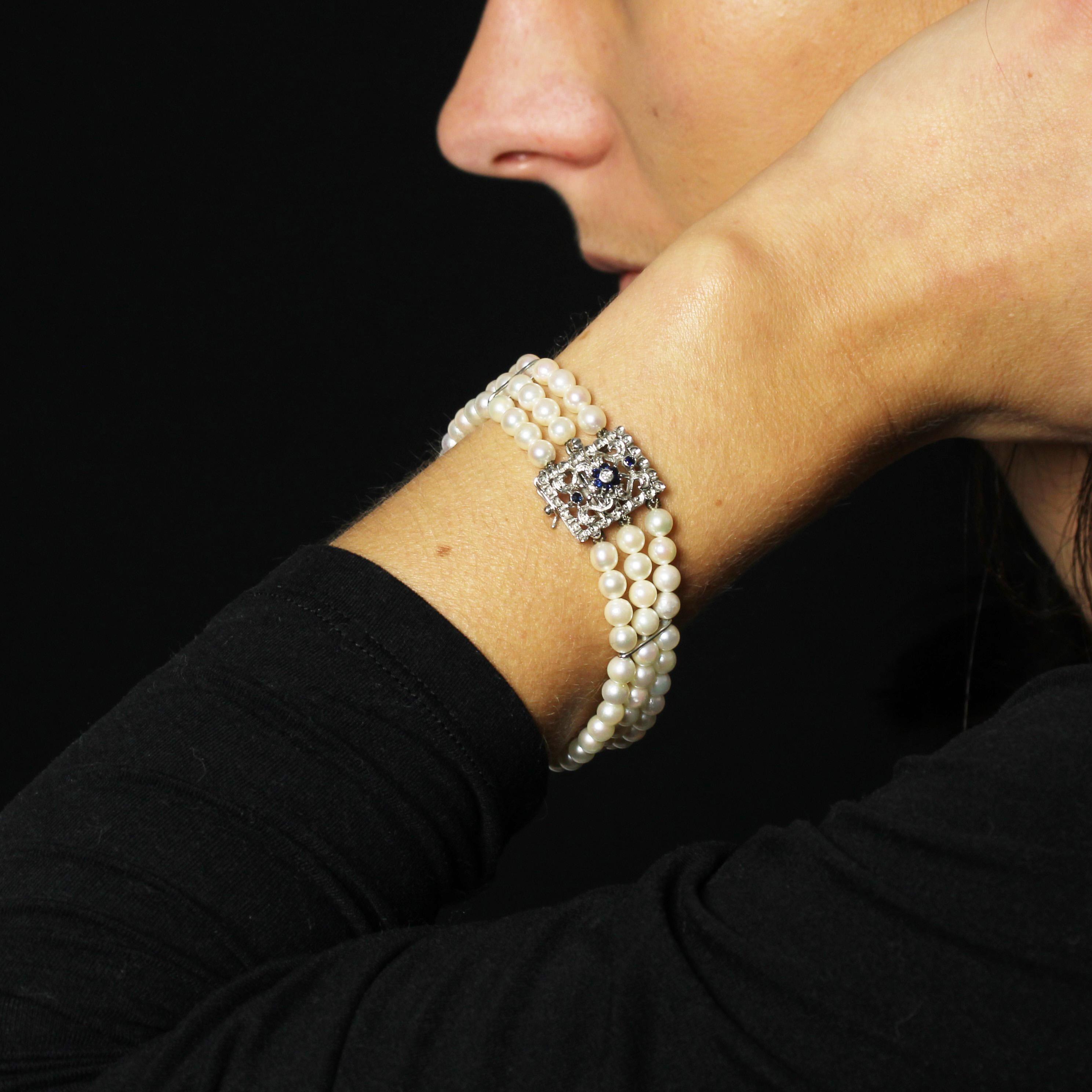 Bracciale con 3 file di perle coltivate rotonde, di colore bianco perlato orientale, tenute insieme da 4 fermagli in oro bianco. La chiusura è a cricchetto con 8 fermi di sicurezza in oro bianco 18 carati traforato e cesellato. È incastonato con 2