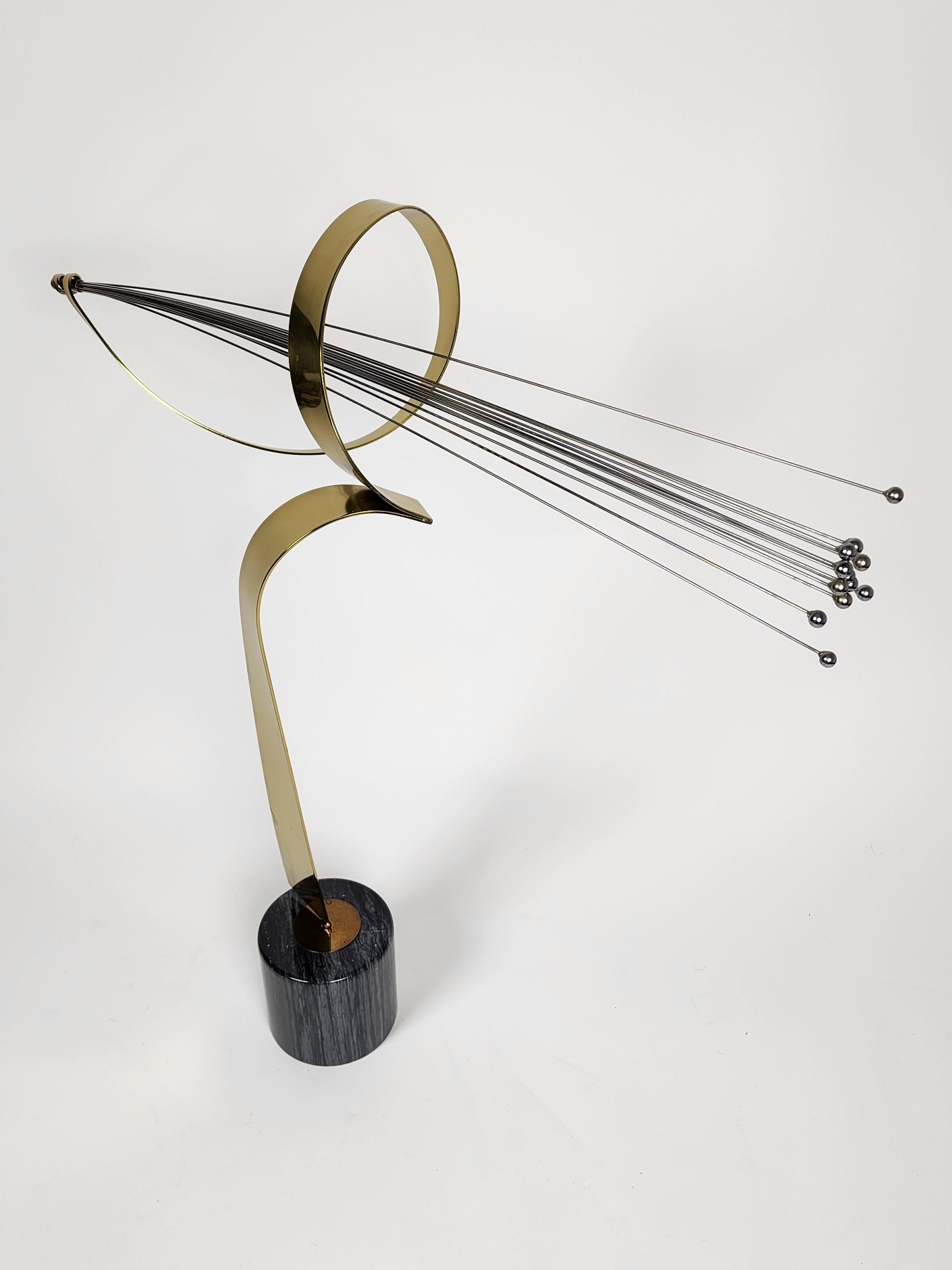 Elegant, fluid, bold brass sculpture with chrome rods from Curtis Jere evoquing a shooting star with its trail fo light. 

The rotating structure sit on a polished marble base.
