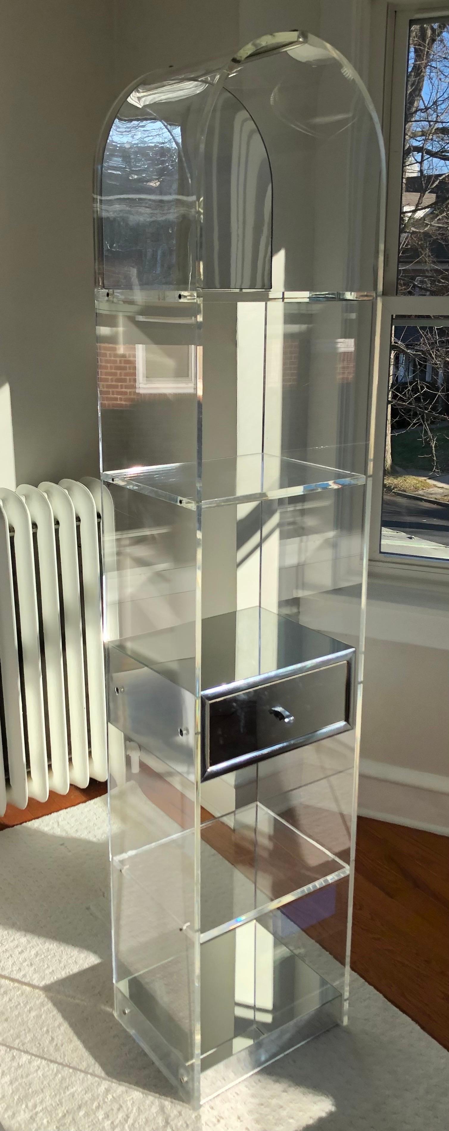 This is a 1970s Custom Domed Lucite Etagere with Chrome details.

It measures 12 inches deep, 15 inches wide and is 71 inches tall. The drawer is not functional. 