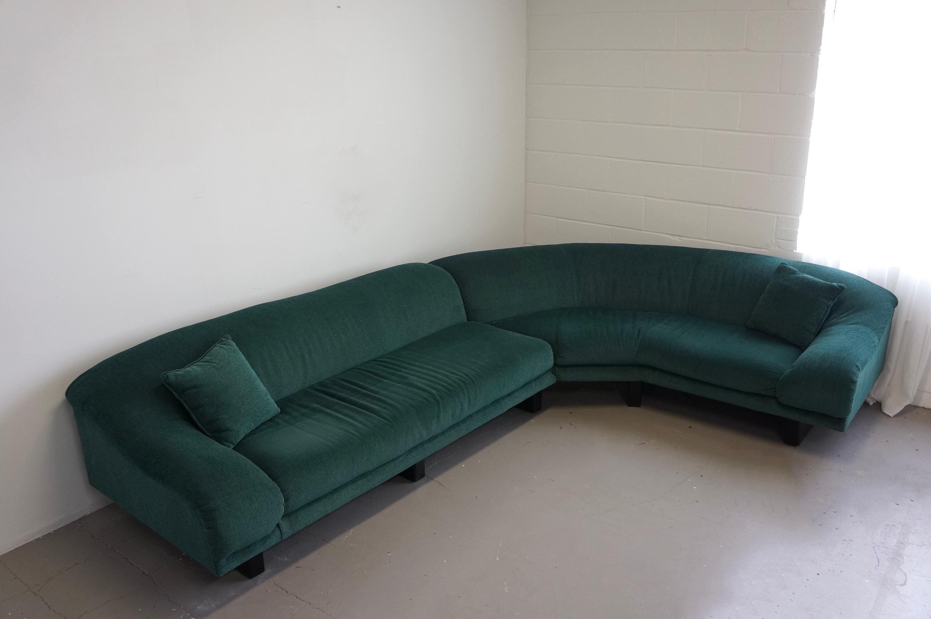 A Stunning curved sectional in gorgeous green fabric. It was made in the 1970s. It is two pieces and it’s curved which makes for a spectacular shape. 
It’s in good vintage condition, the fabric has no rips or tears. There’s some folding on the