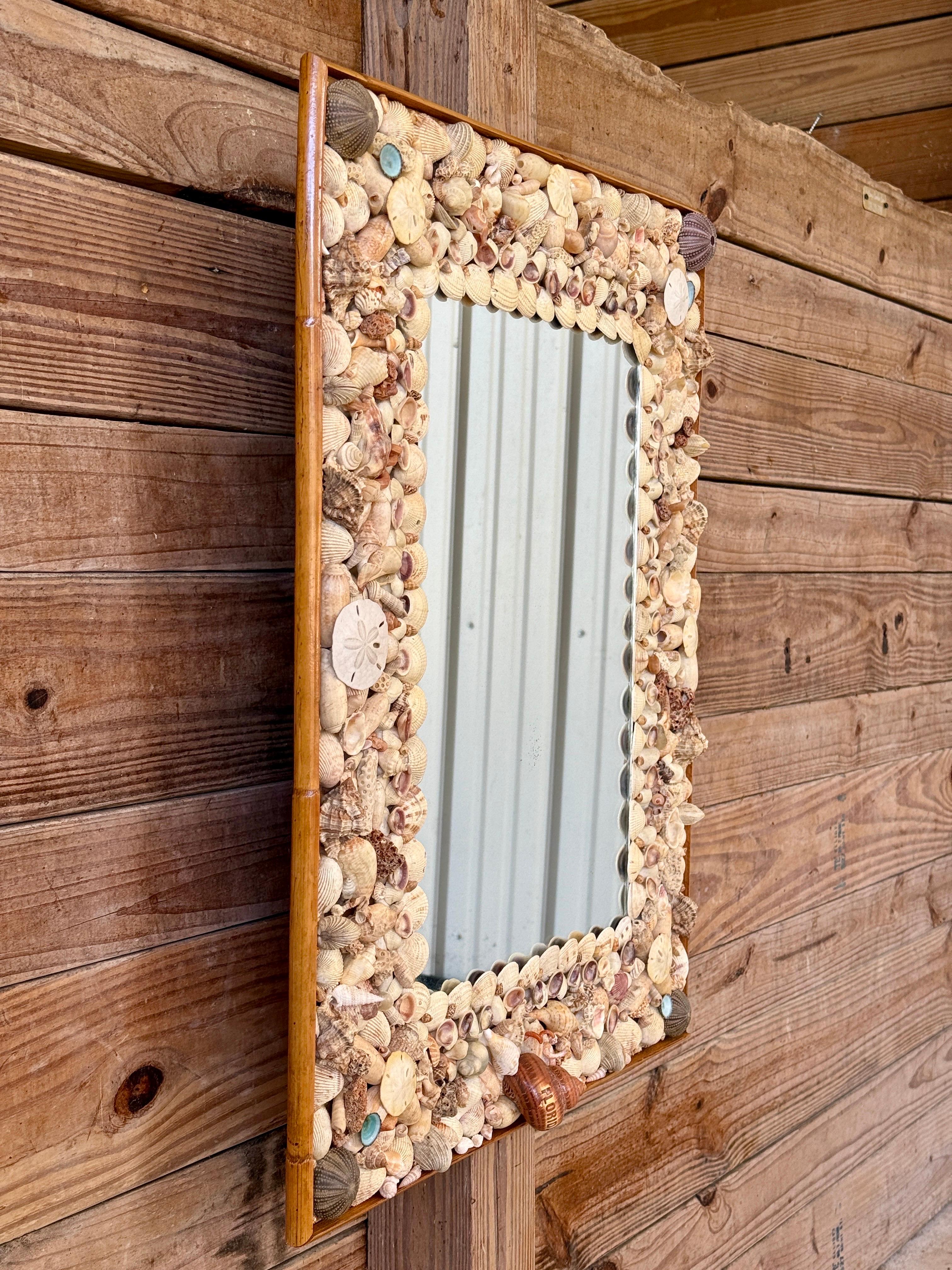 Véritable œuvre d'art de la Nature Trueing, ce miroir mural personnalisé des années 1970 est orné d'une mosaïque complexe de coquillages naturels, de coraux et de dollars de sable, chacun d'entre eux étant disposé de manière à créer un chef-d'œuvre