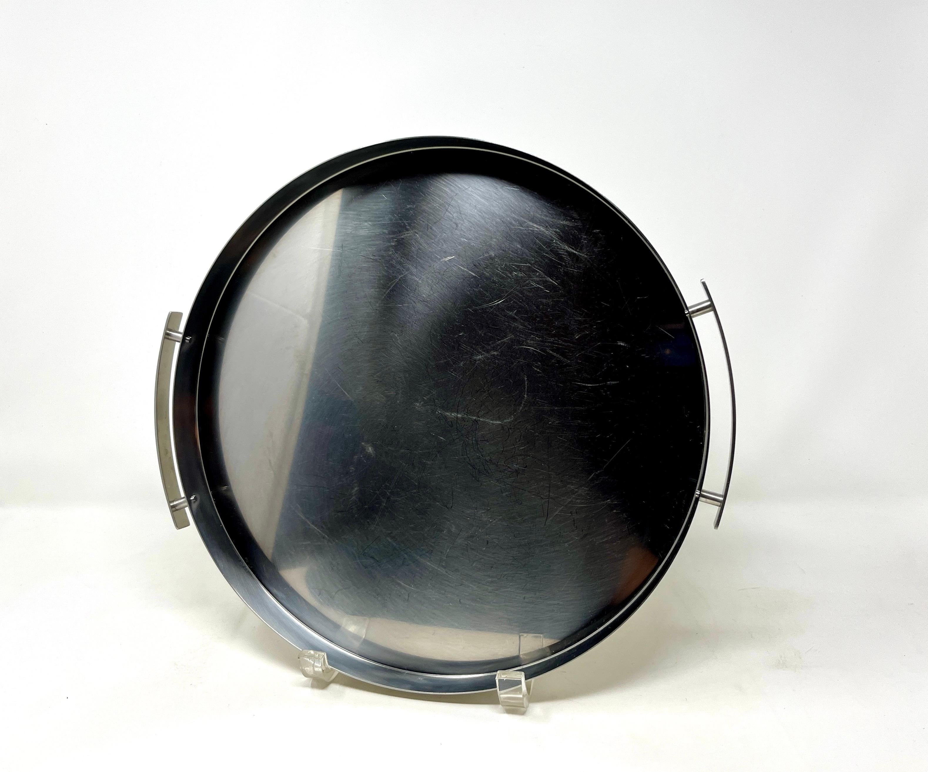 Arne Jacobsen ha disegnato questo intramontabile vassoio da portata o da cocktail per Stelton nel 1970 circa. Realizzato in acciaio inossidabile con doppi manici. Nessuna marcatura ma vero Stelton. Bellissima aggiunta alla tua collezione Cylinda