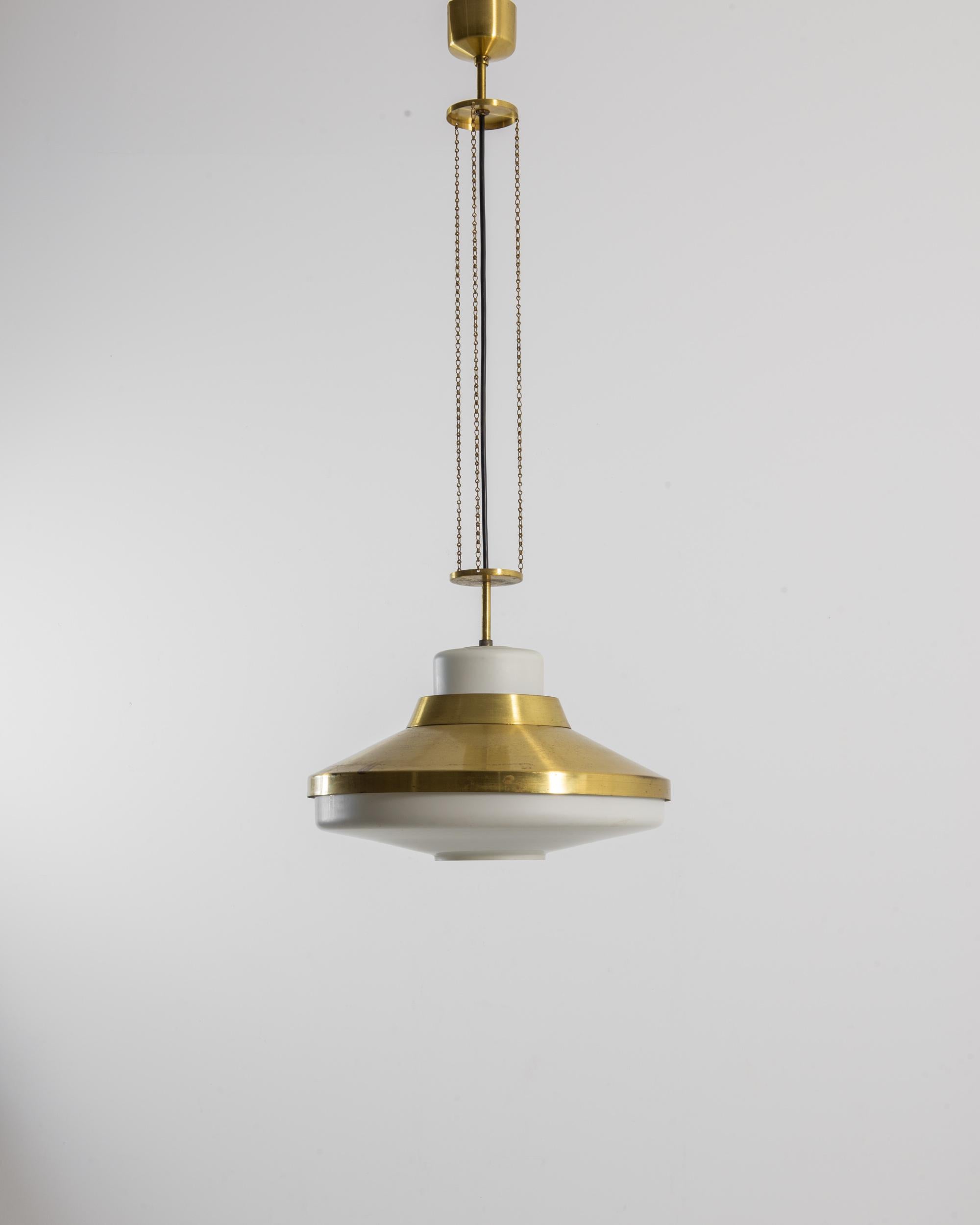Art Deco glamor meets Industrial simplicity in this vintage brass pendant lamp. Made in Czechia in the 1970s, the wide, streamlined slope of the lamphead is suspended from a slender arrangement of disks and chains, which bring a three-fold symmetry