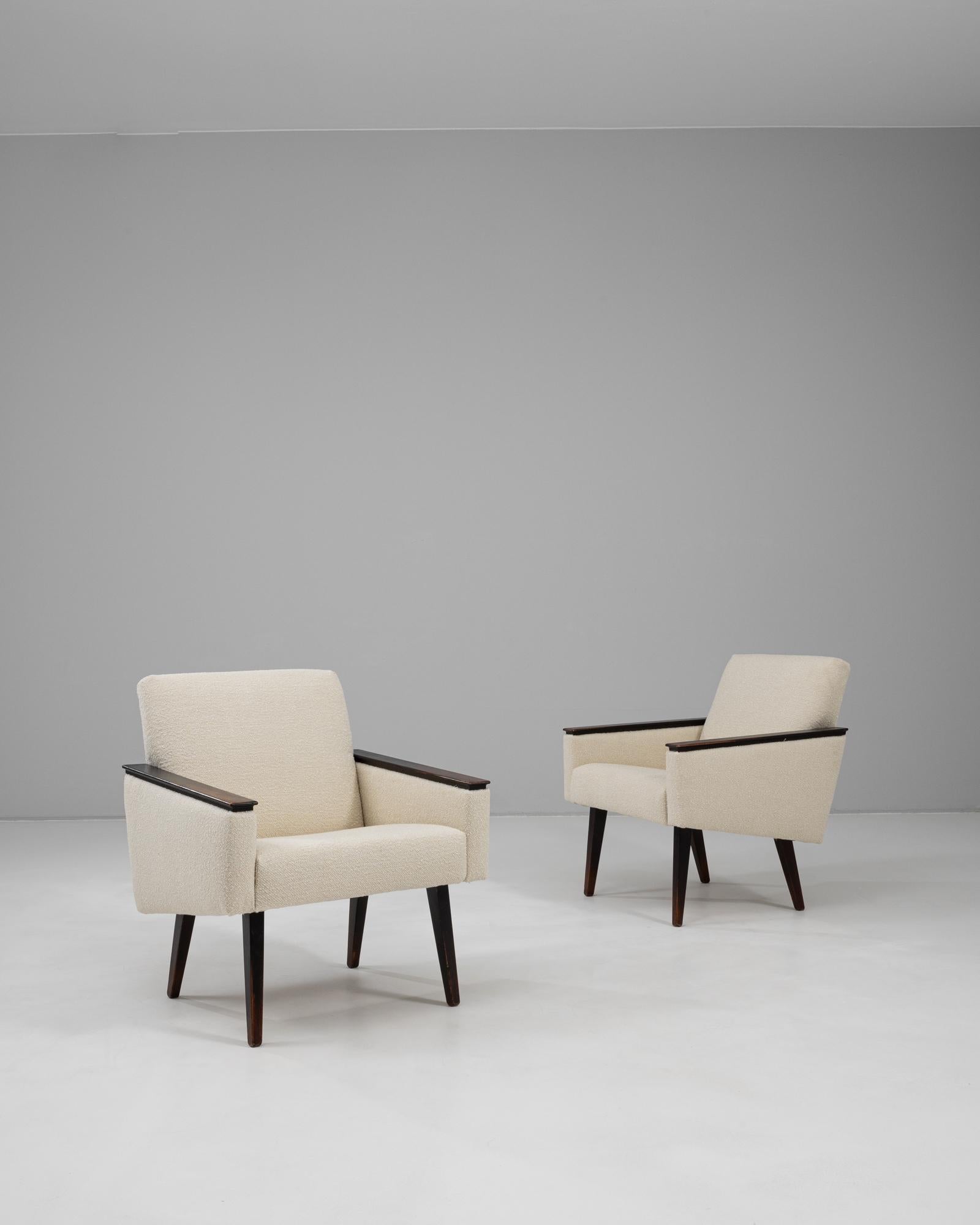 Un elegante par de sillones de mediados de siglo fabricados por la empresa Gera en la antigua Checoslovaquia durante la década de 1970. Estas sillas presentan líneas limpias, patas ligeramente ahusadas y reposabrazos de madera oscura que contrastan